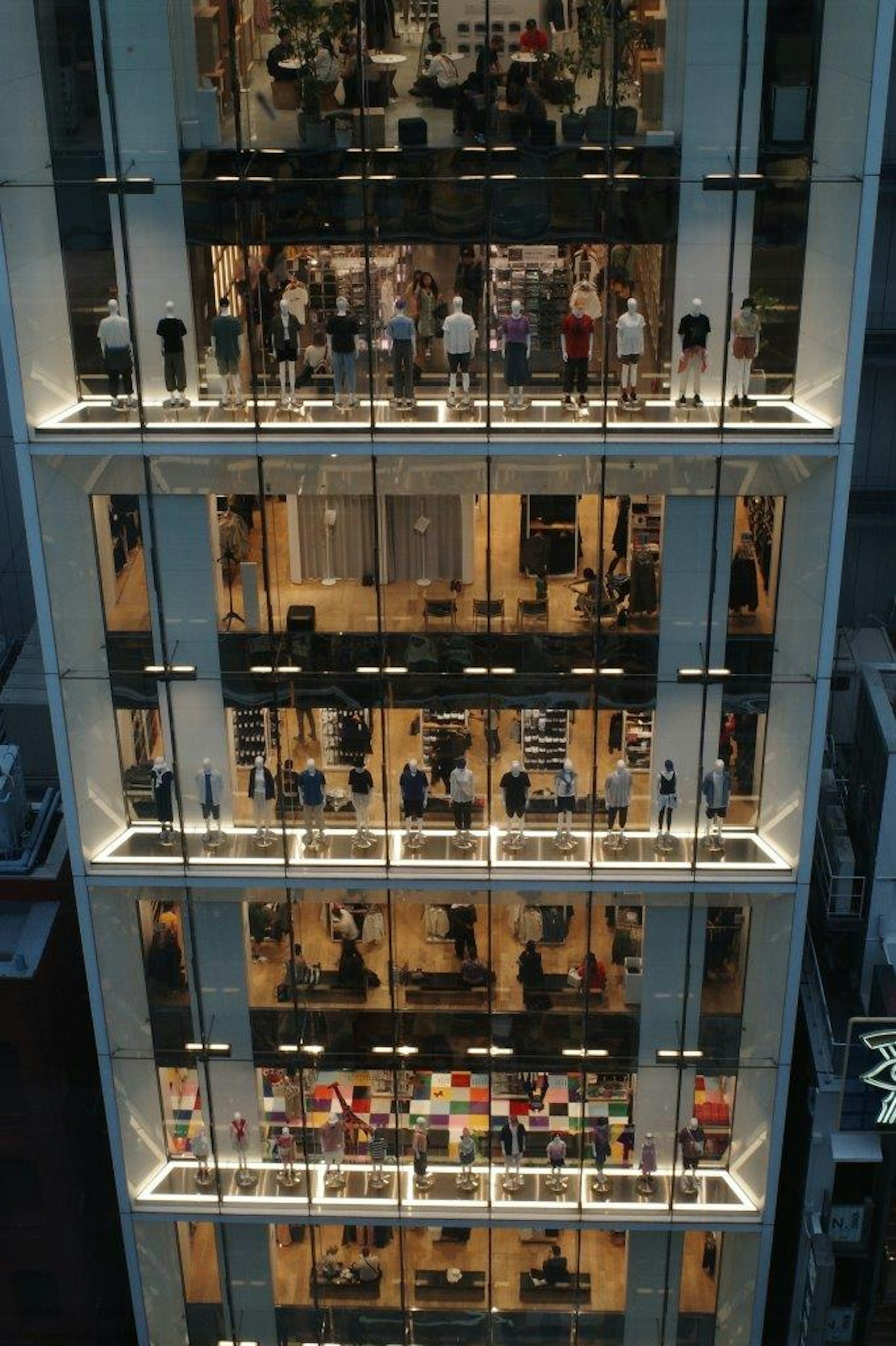 Exhibiciones de ropa en un edificio urbano con compradores visibles