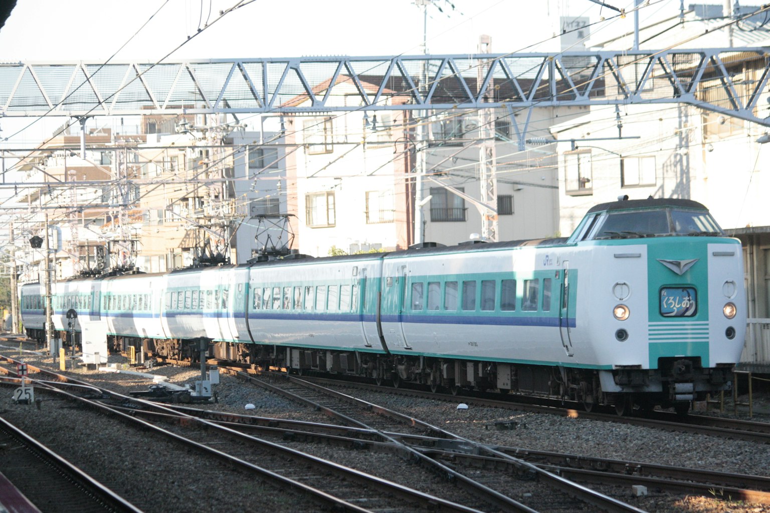 Un train bleu et blanc est arrêté à une gare