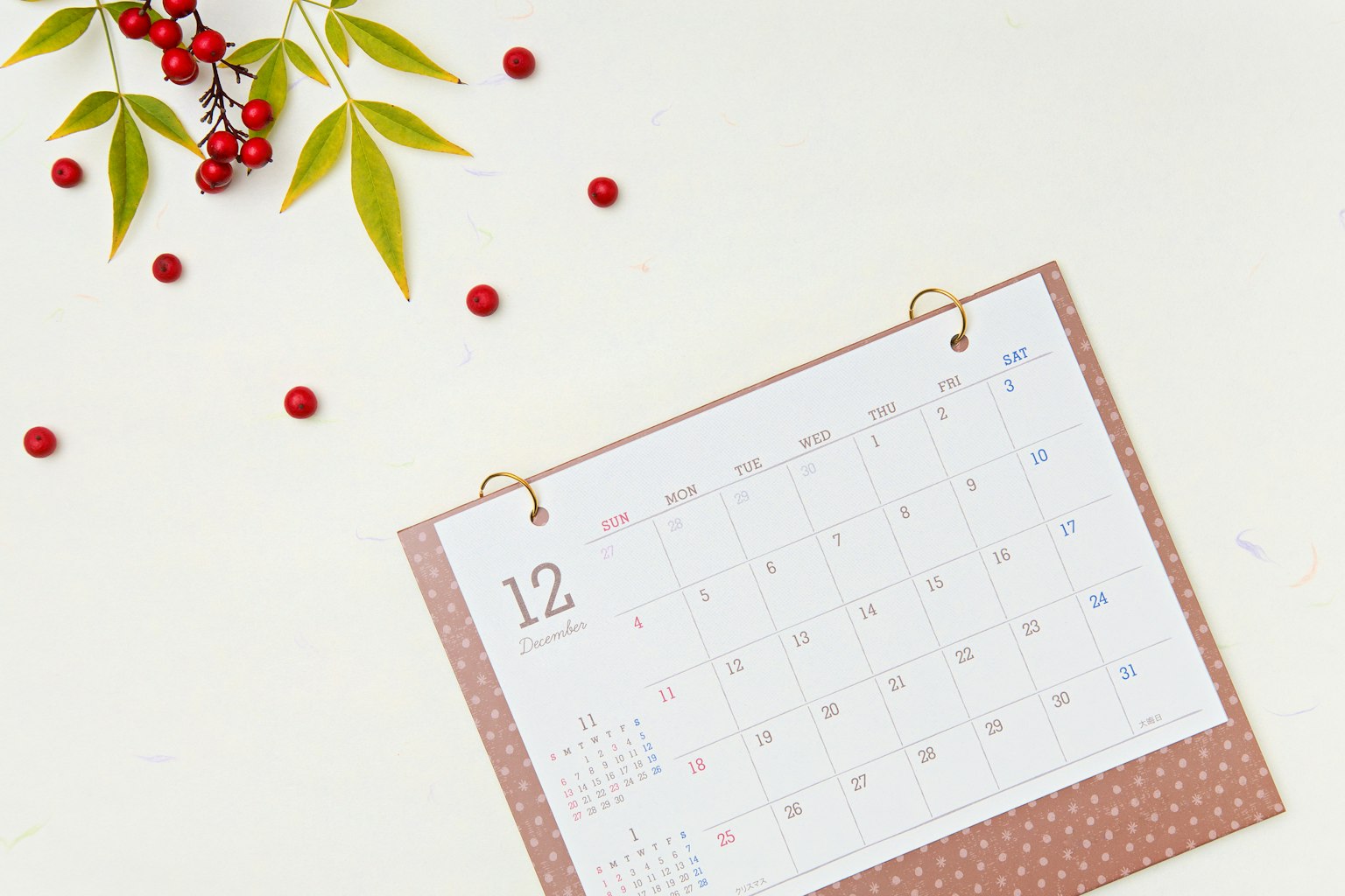Calendario de diciembre con bayas rojas y hojas verdes