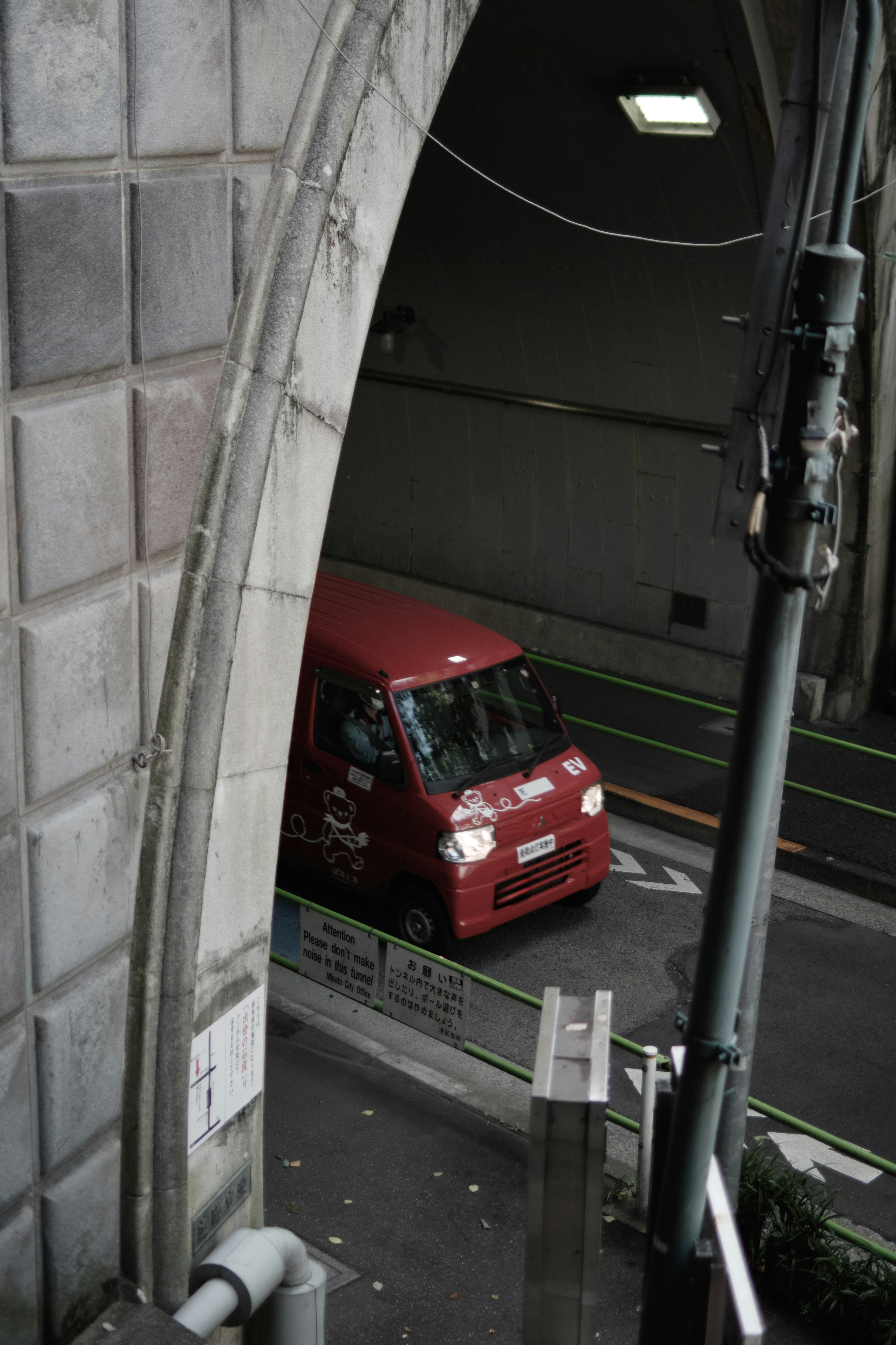 愛宕トンネル内を走る赤い軽トラックの郵便車