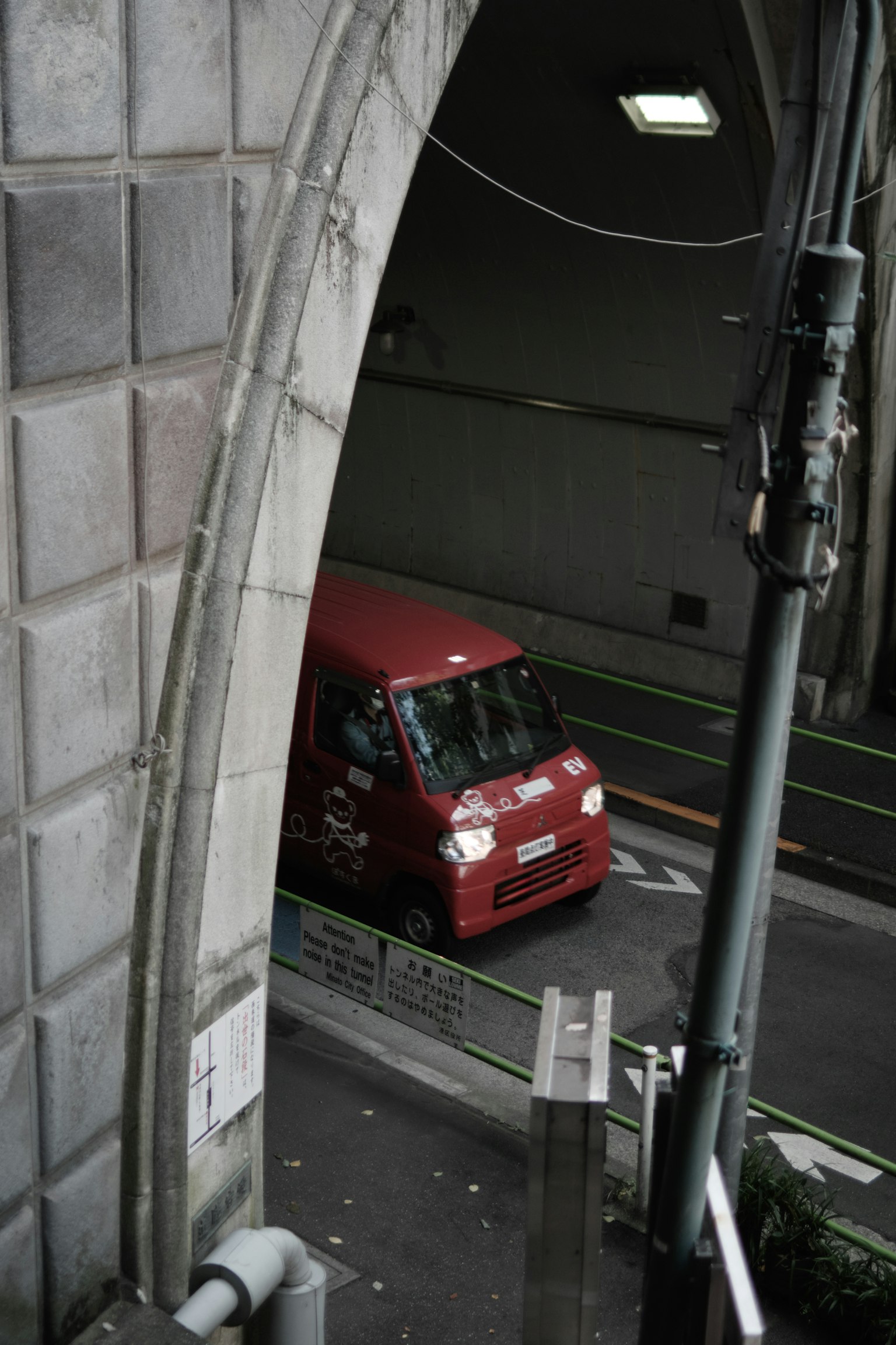 Un veicolo rosso è parcheggiato all'ingresso di un tunnel ad arco
