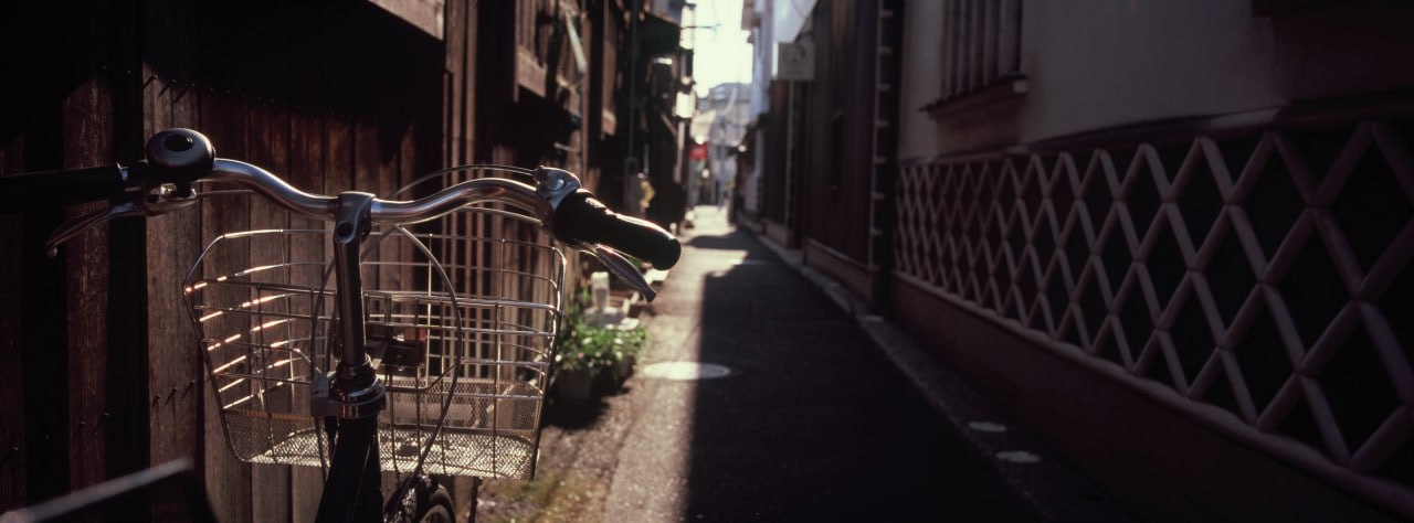 路地に並ぶ自転車と店先のある商店街の軒先