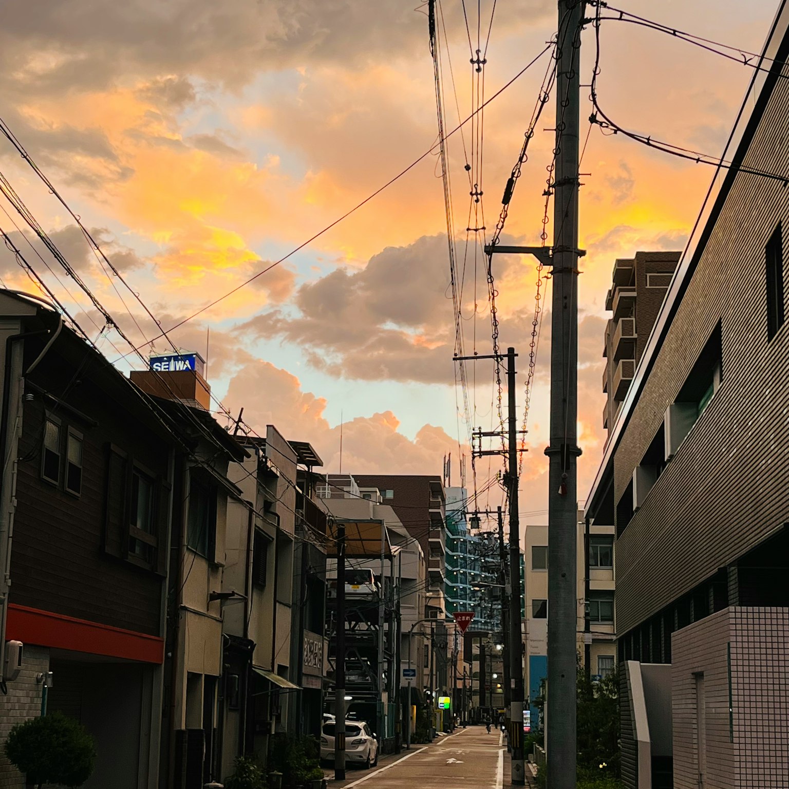 Vista di strada con cielo al tramonto e nuvole colorate edifici antichi e moderni lungo la strada stretta