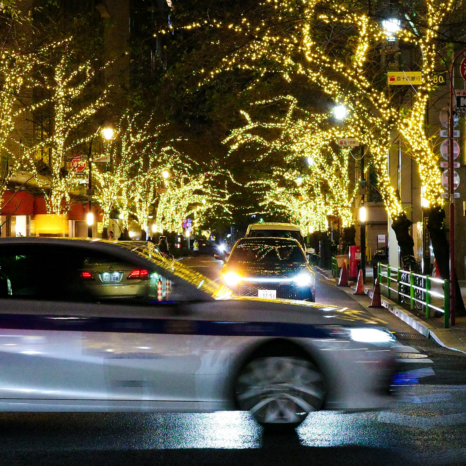 Strada cittadina illuminata da luci festive con taxi in movimento