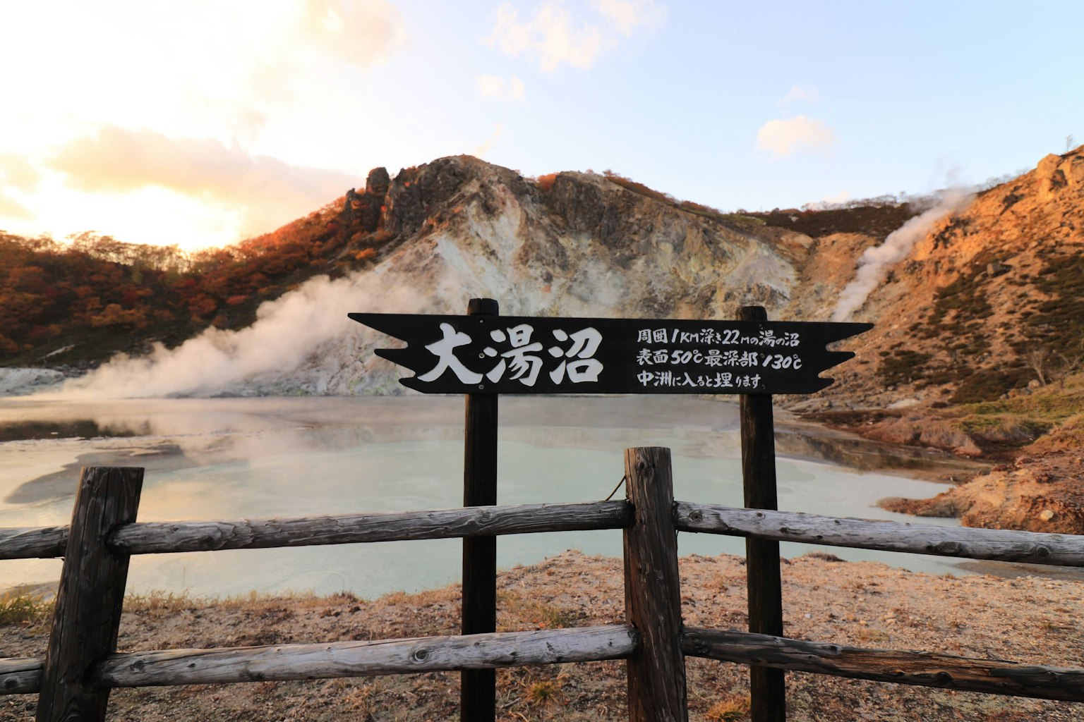 Scenic view of Oyunuma hot spring with sign in foreground