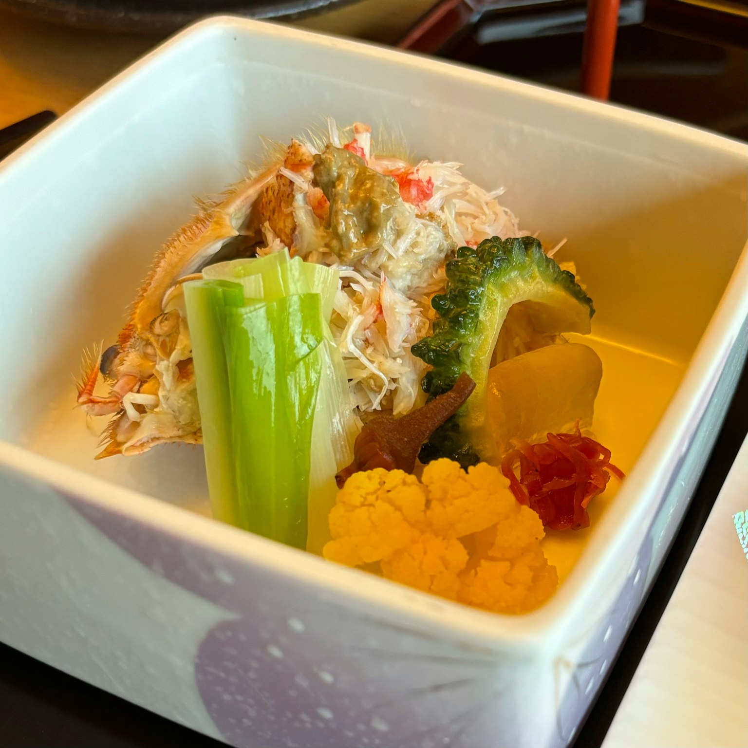 一個小碗，盛有色彩繽紛的蔬菜和螃蟹菜餚
