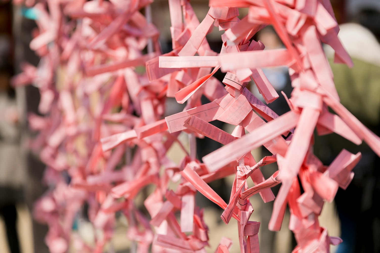 Colorful pink paper strips tied together in a decorative display