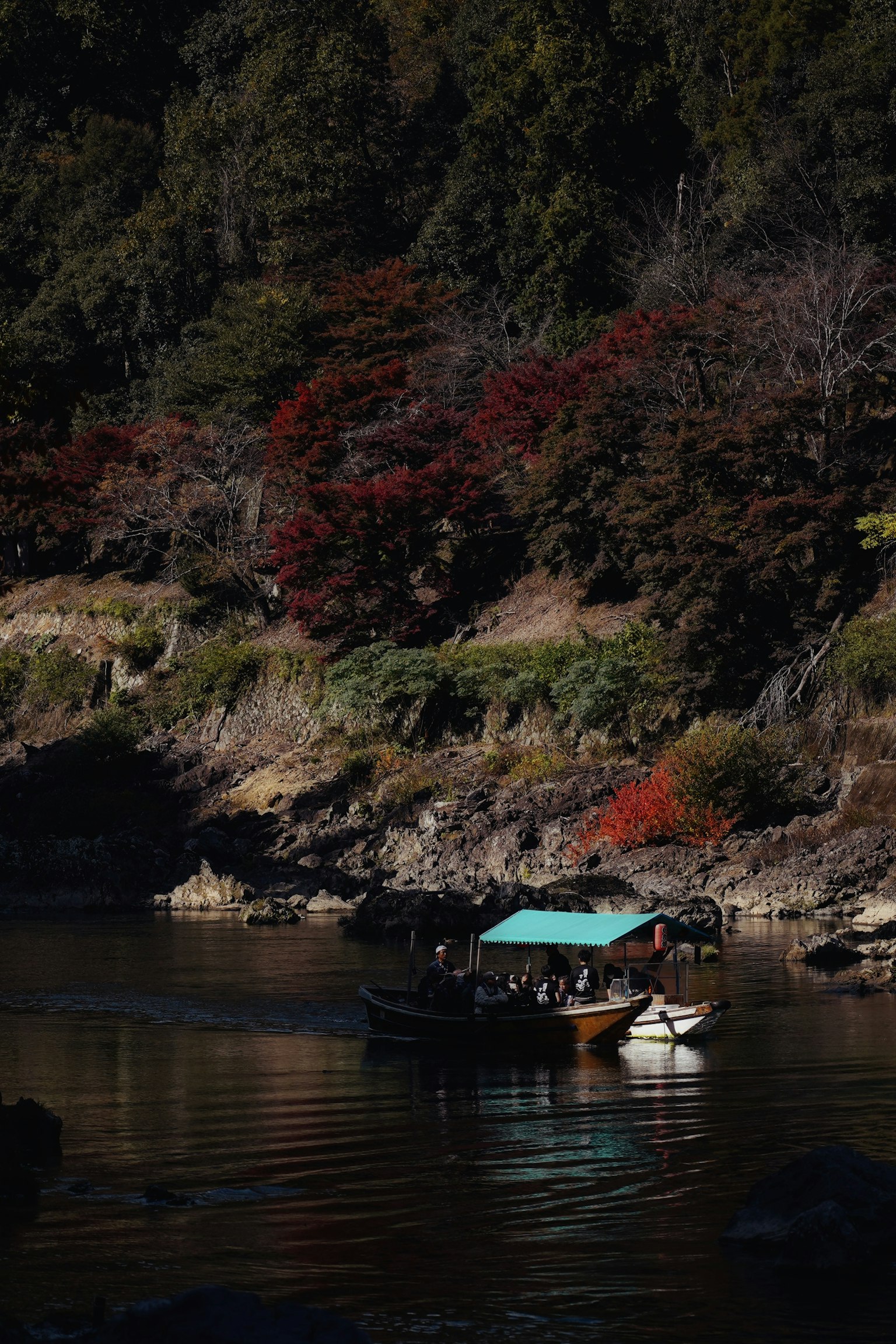 静かな川に浮かぶ小舟と紅葉した木々の風景