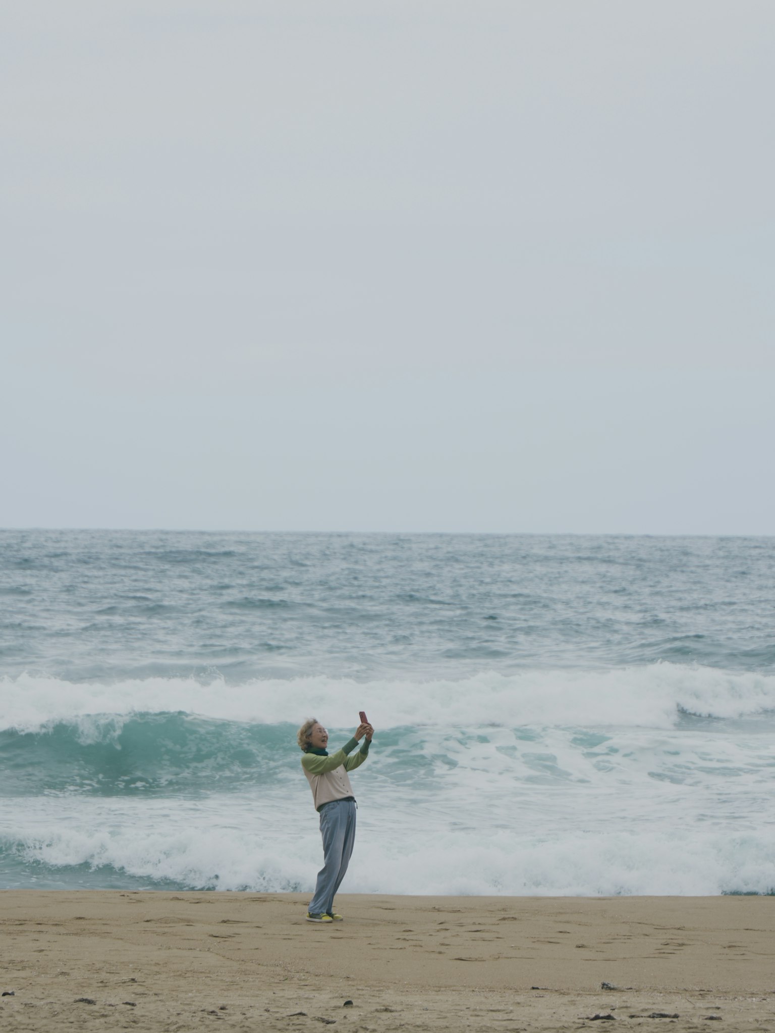 Personne prenant un selfie sur la plage avec des vagues en arrière-plan