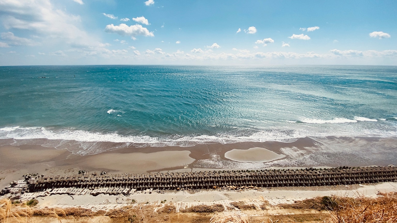 Scenic view of a beach with blue ocean and sky Waves crashing on the shore