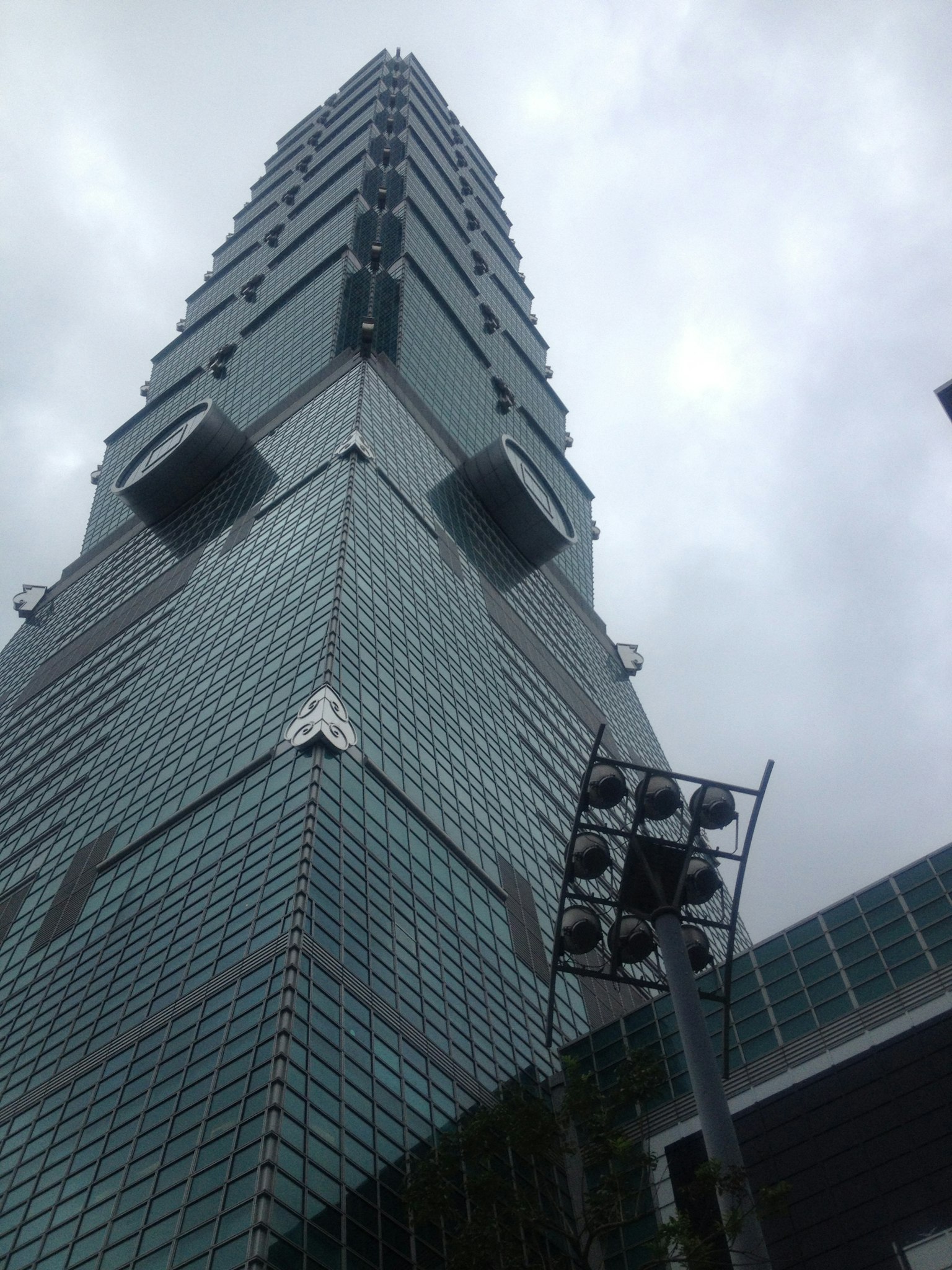 Foto del grattacielo Taipei 101 vista dal basso sotto un cielo nuvoloso che mostra la sua architettura distintiva