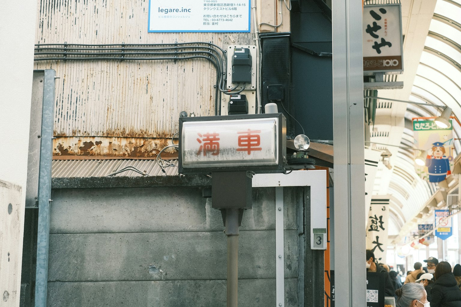 Scène d'une rue commerçante étroite avec un vieux panneau et des murs usés