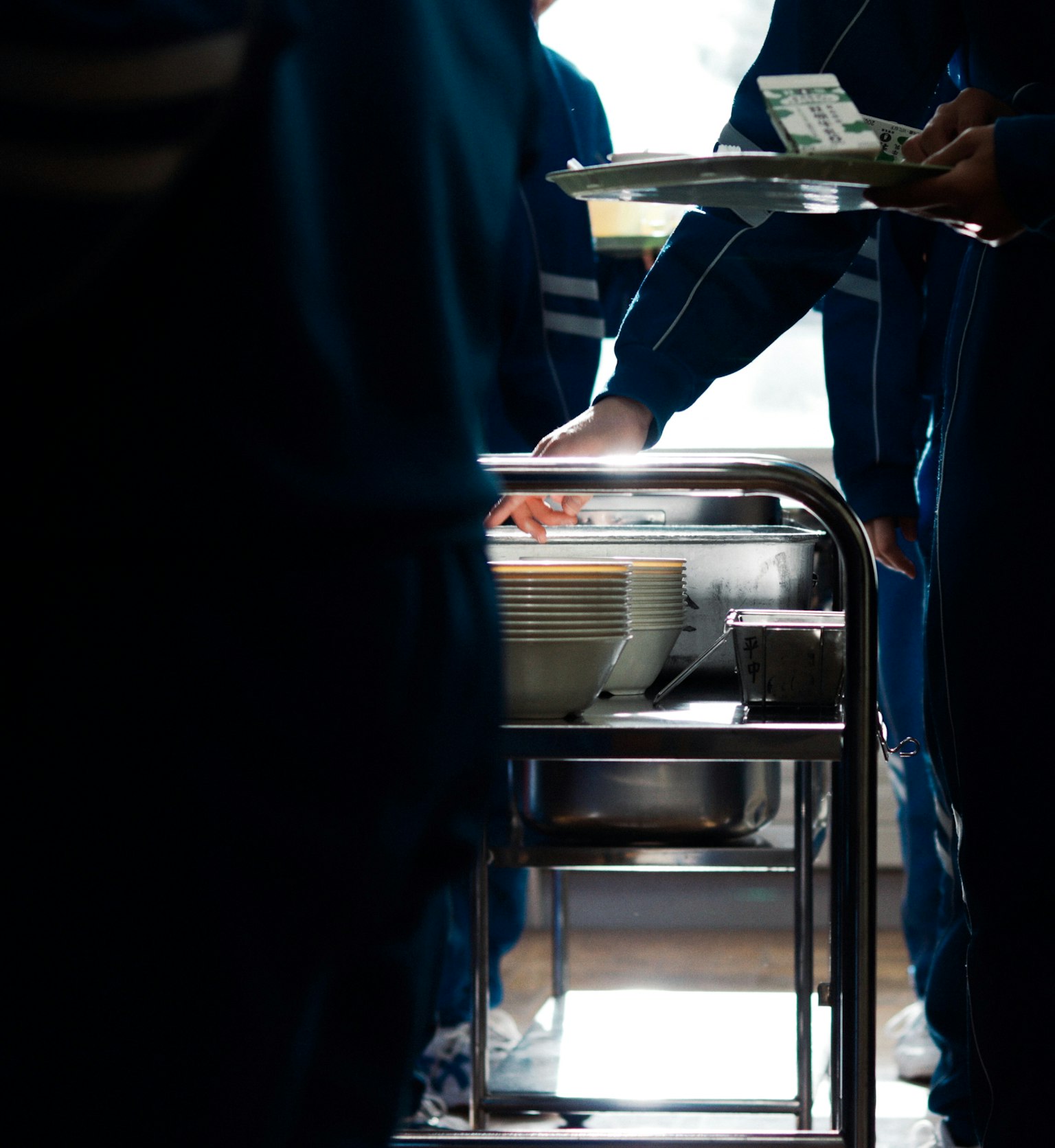 Siluet siswa yang menyajikan makanan di kafetaria