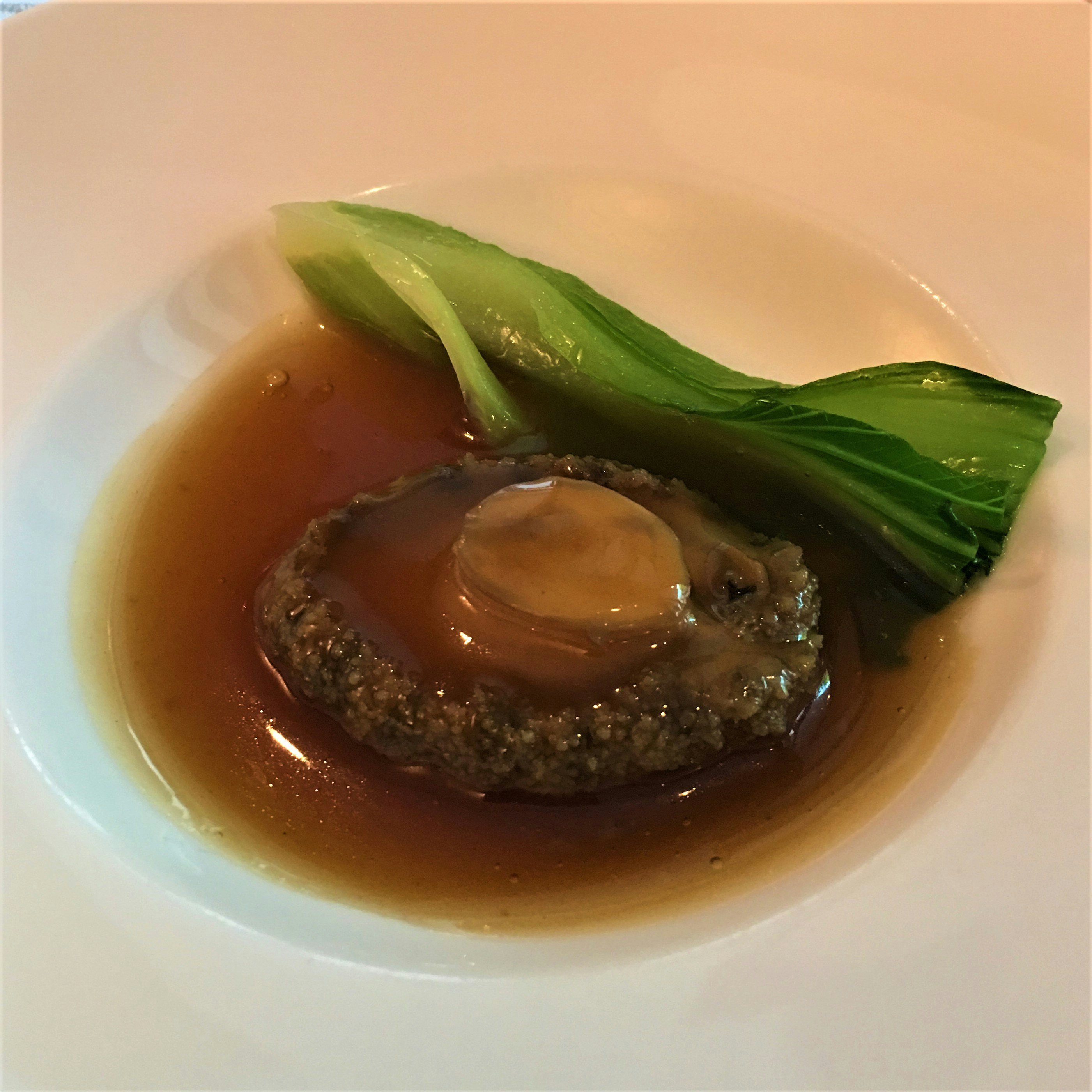 清湯中漂浮的鮑魚風味食材與青菜