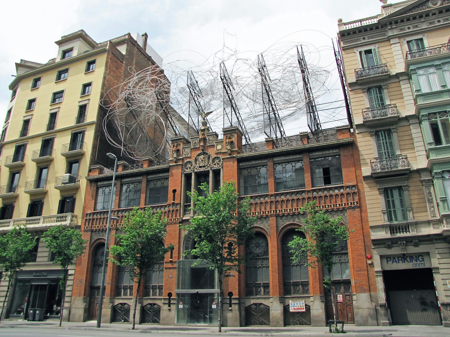 Bâtiment architectural unique à Barcelone avec une façade en briques rouges et une structure en fil distincte