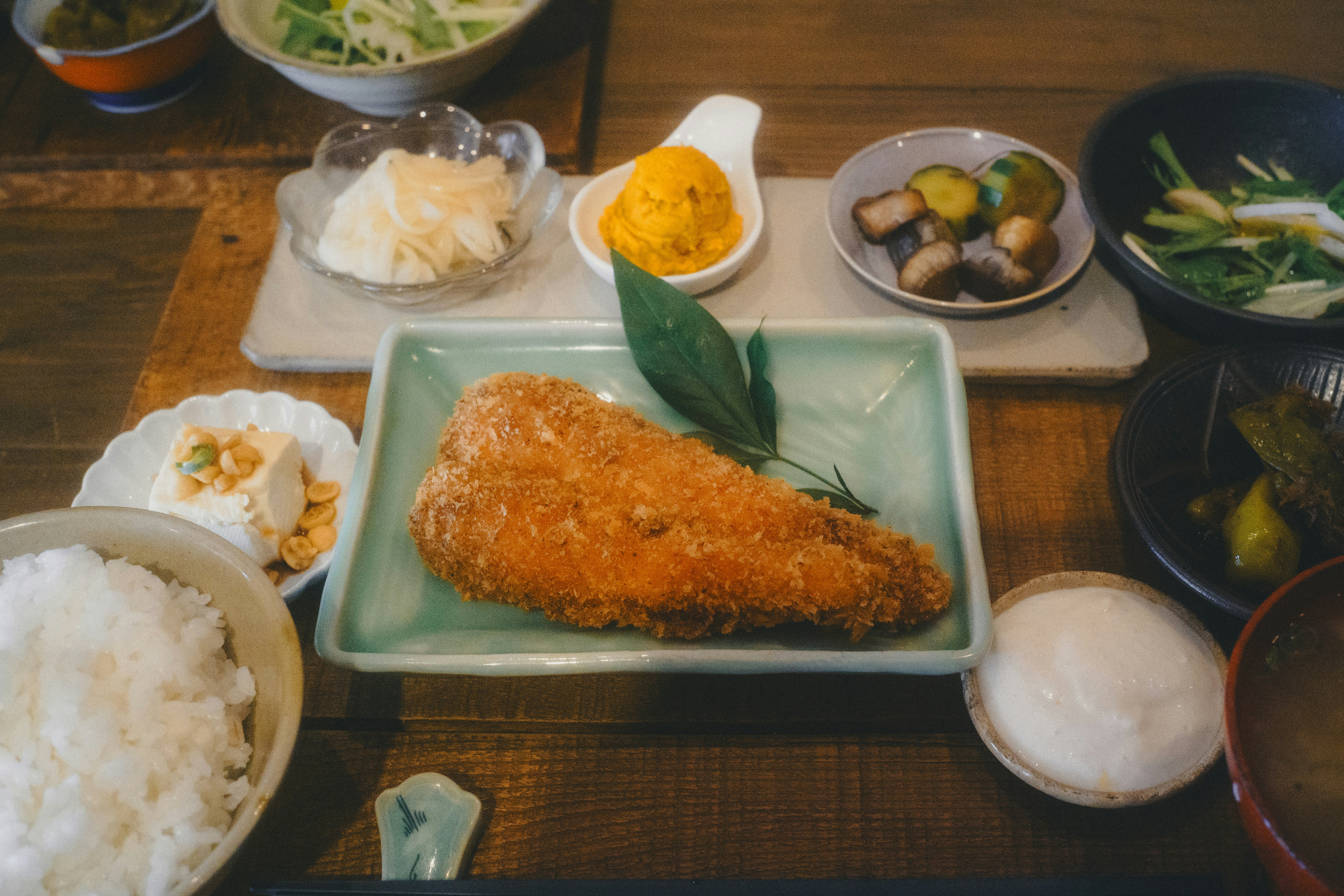 定食の盛り合わせと揚げ物が並ぶ食卓