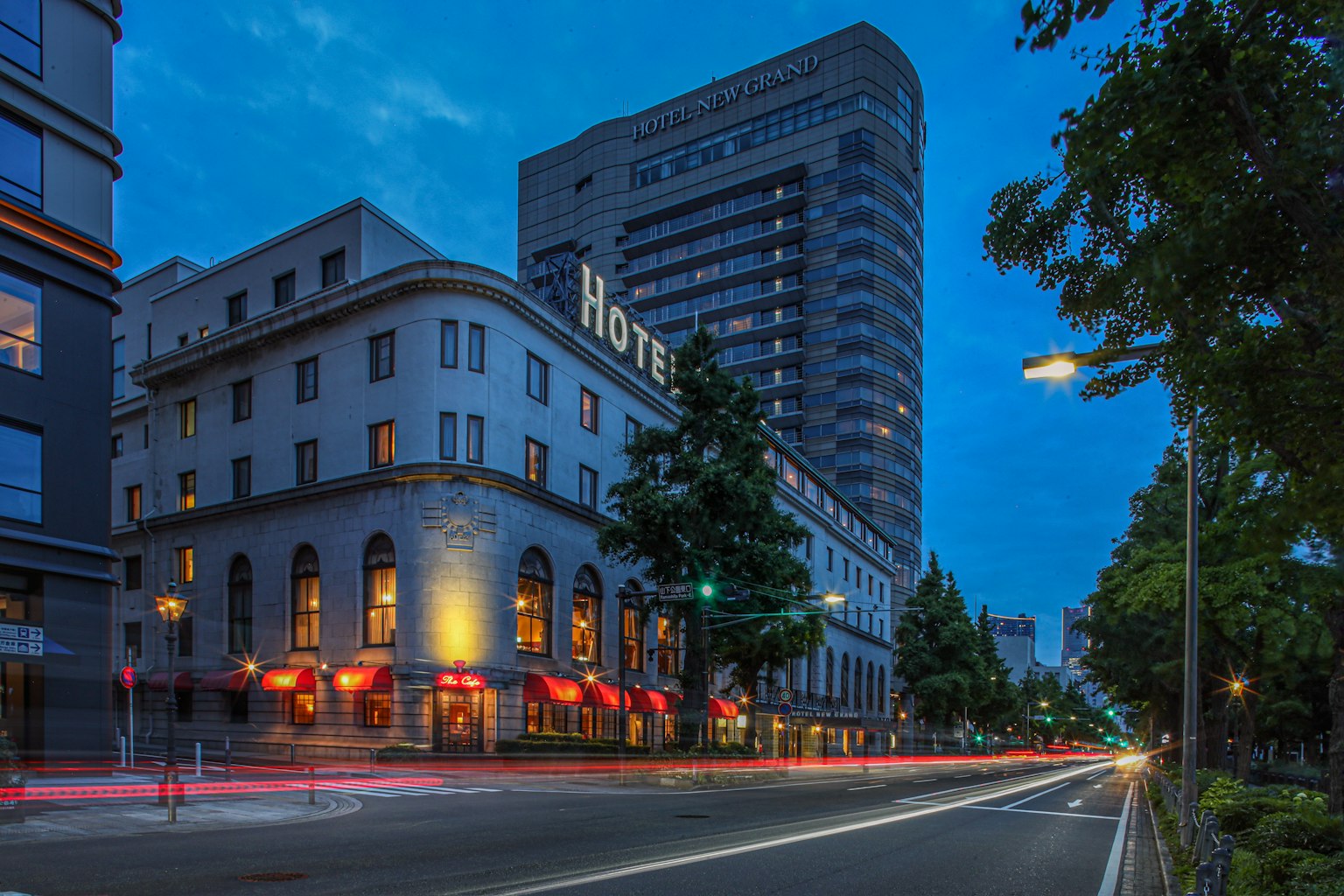 Exterior view of a hotel at night with street lights and traffic