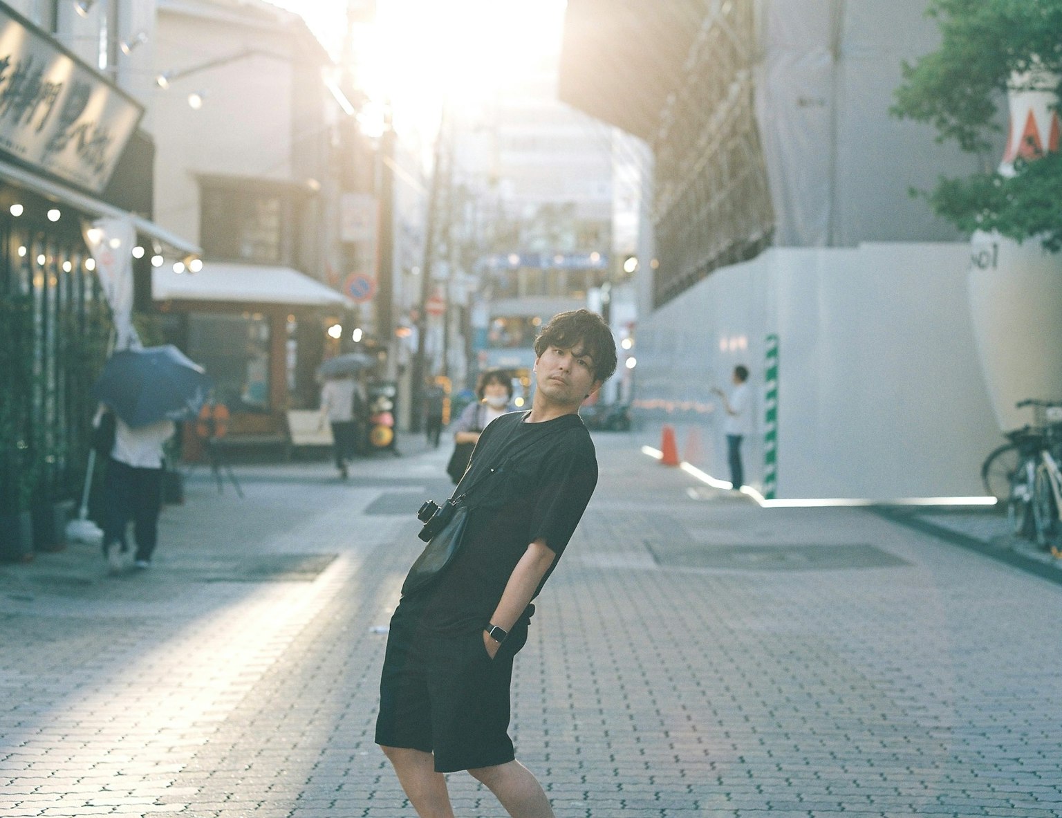 도시 거리에서 포즈를 취하는 여성의 사진 배경에 햇빛이 비치고 있다