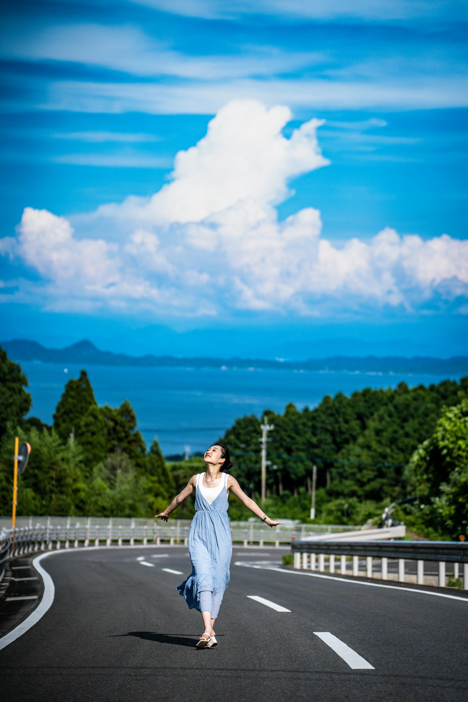 穿著藍色裙子的女人在道路上走，背景美麗