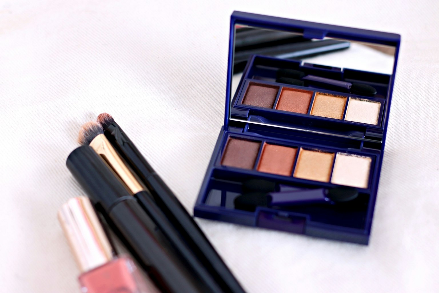 Image présentant une palette de fards à paupières violette et des produits pour les lèvres