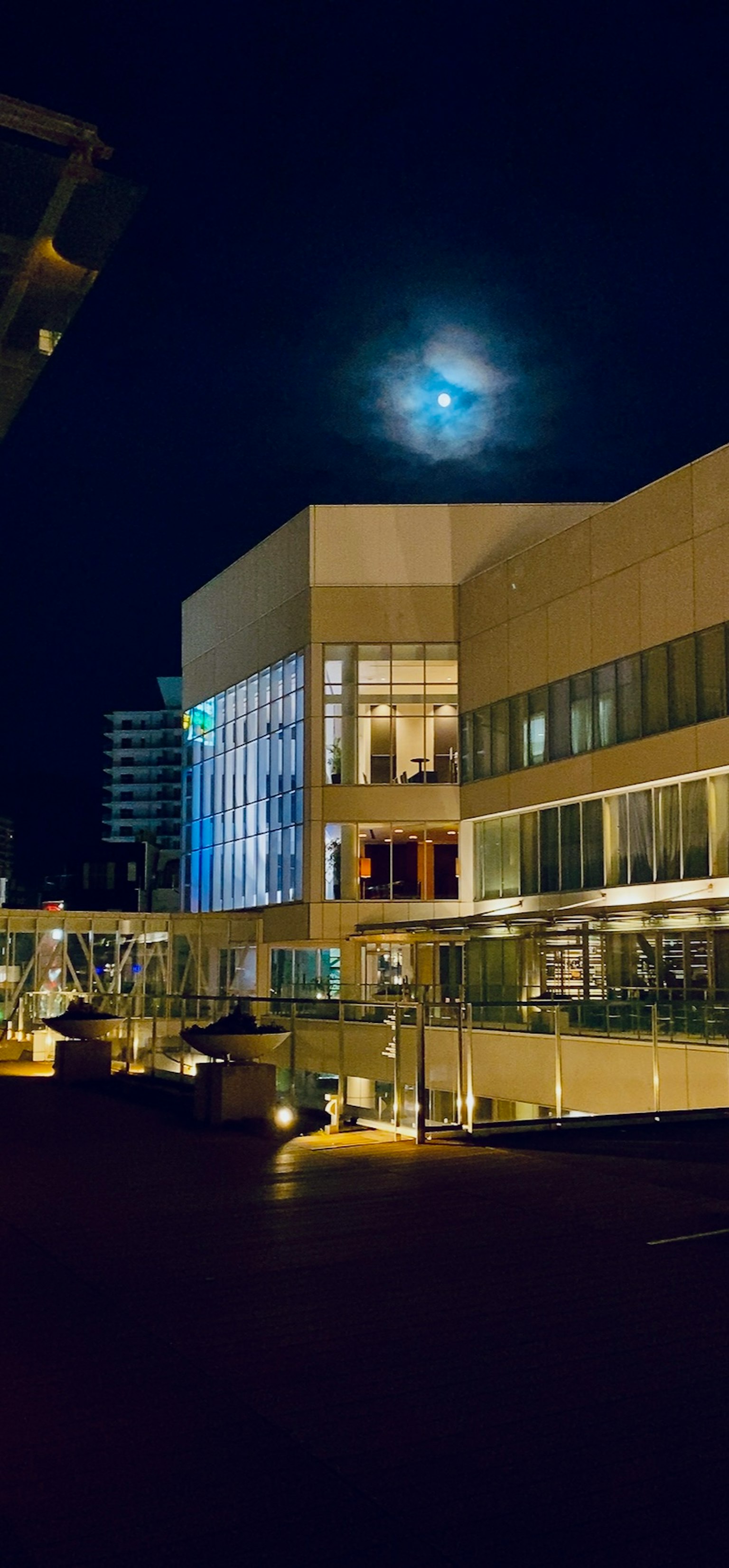 Paesaggio urbano notturno con luna piena e architettura moderna