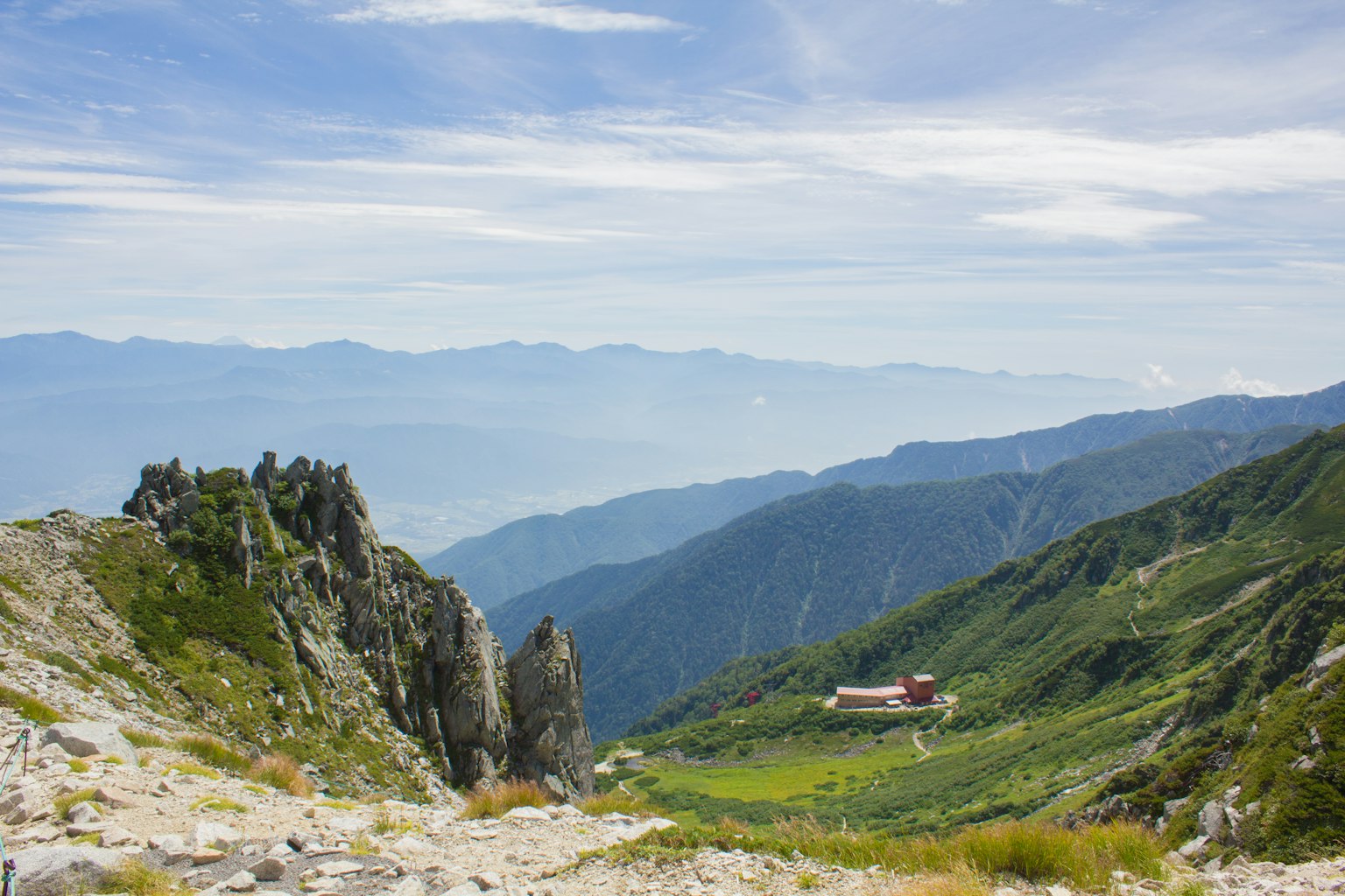 山脈景觀，綠色山谷和一座紅色小屋