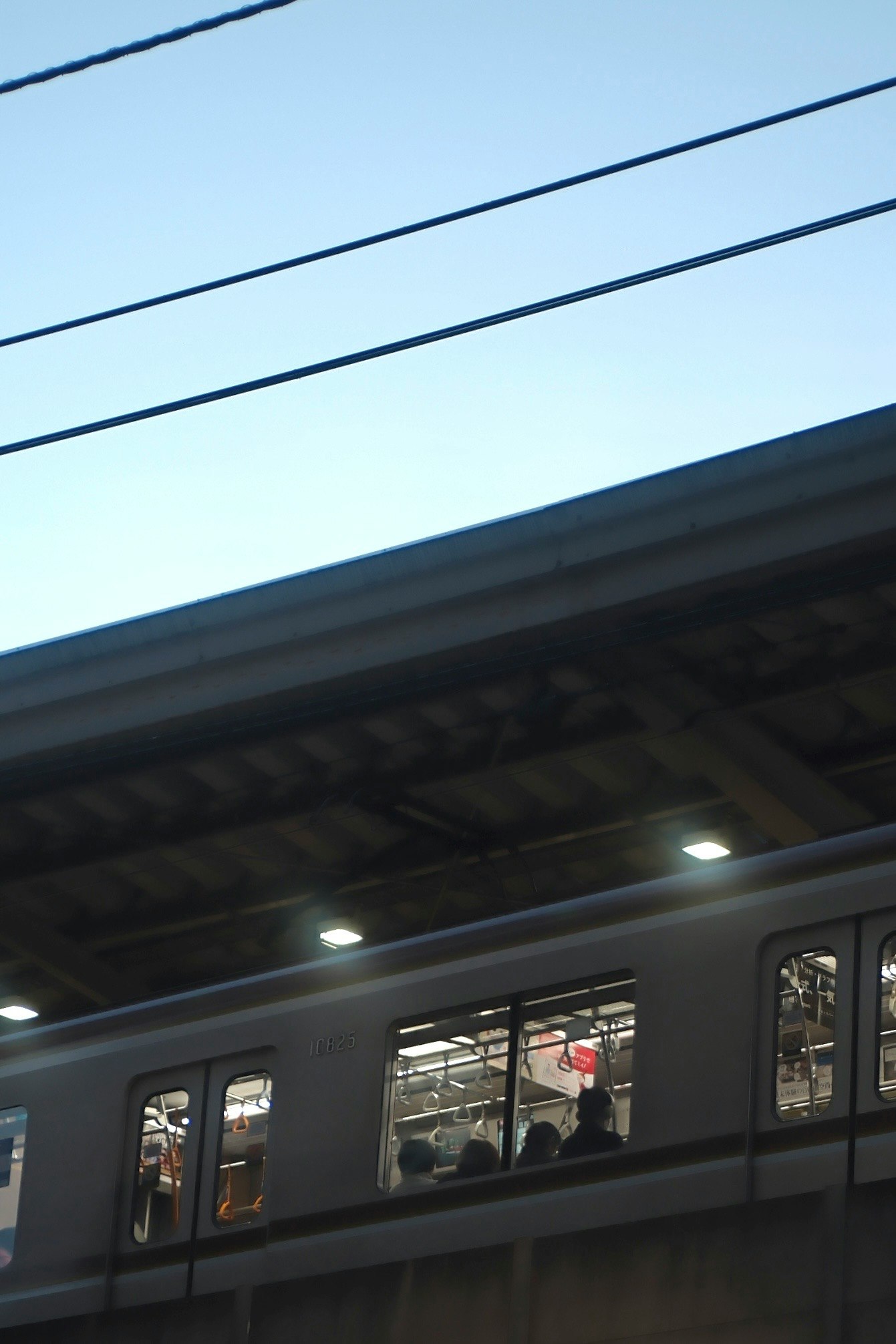 高架を走る電車の車窓とホームの光