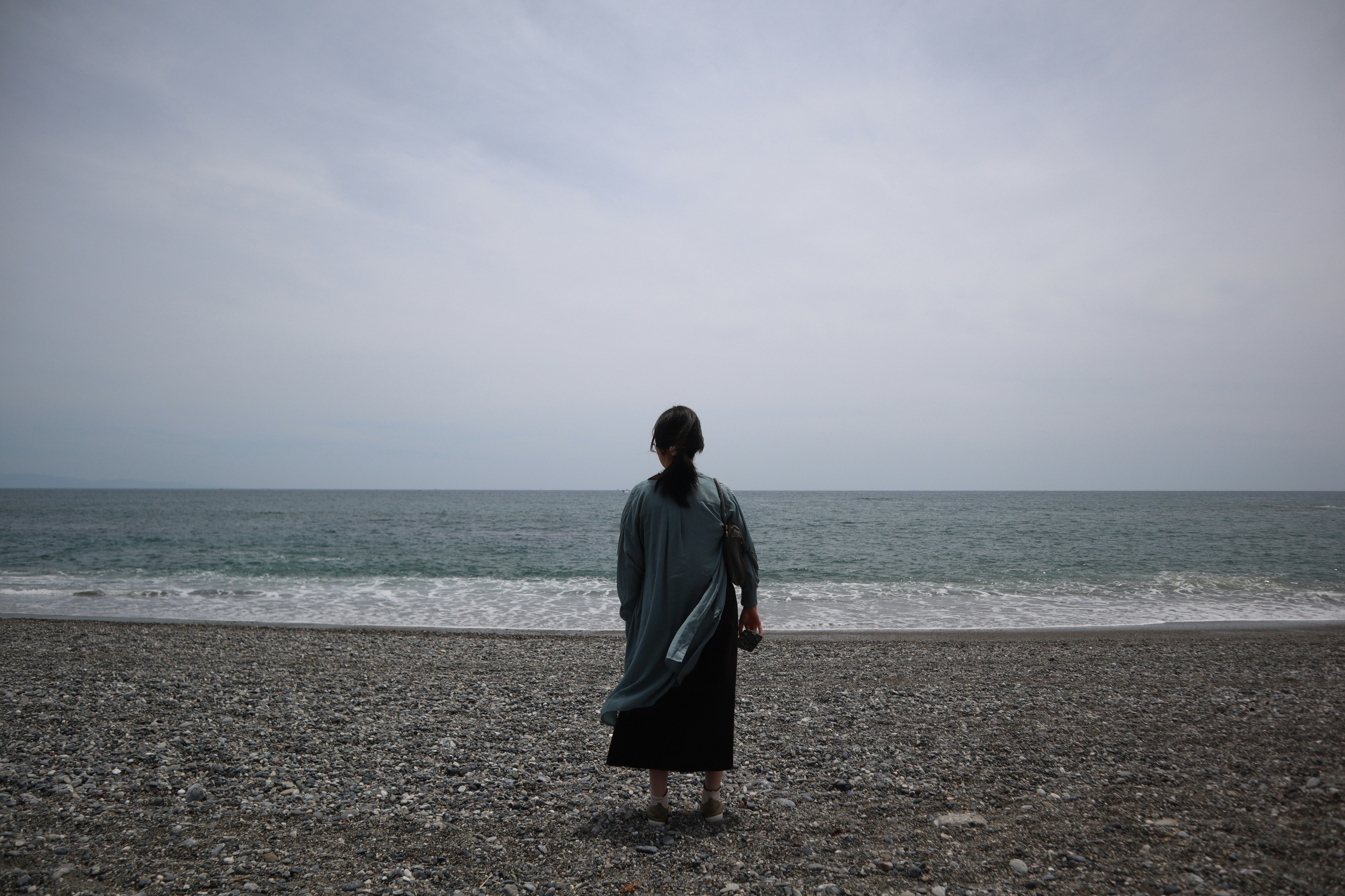 桂浜の海辺で佇む人物の後ろ姿