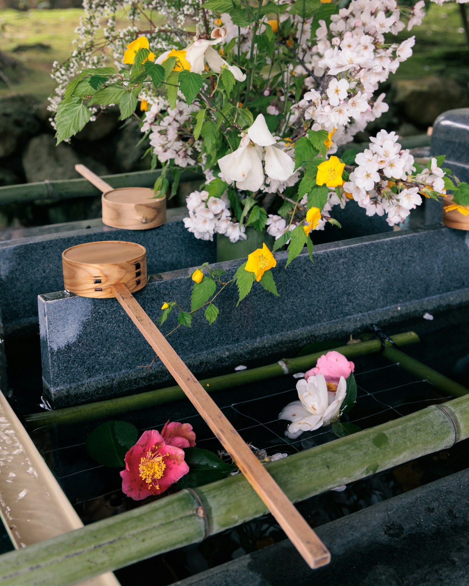 传统日本水盆，配有花卉和竹勺
