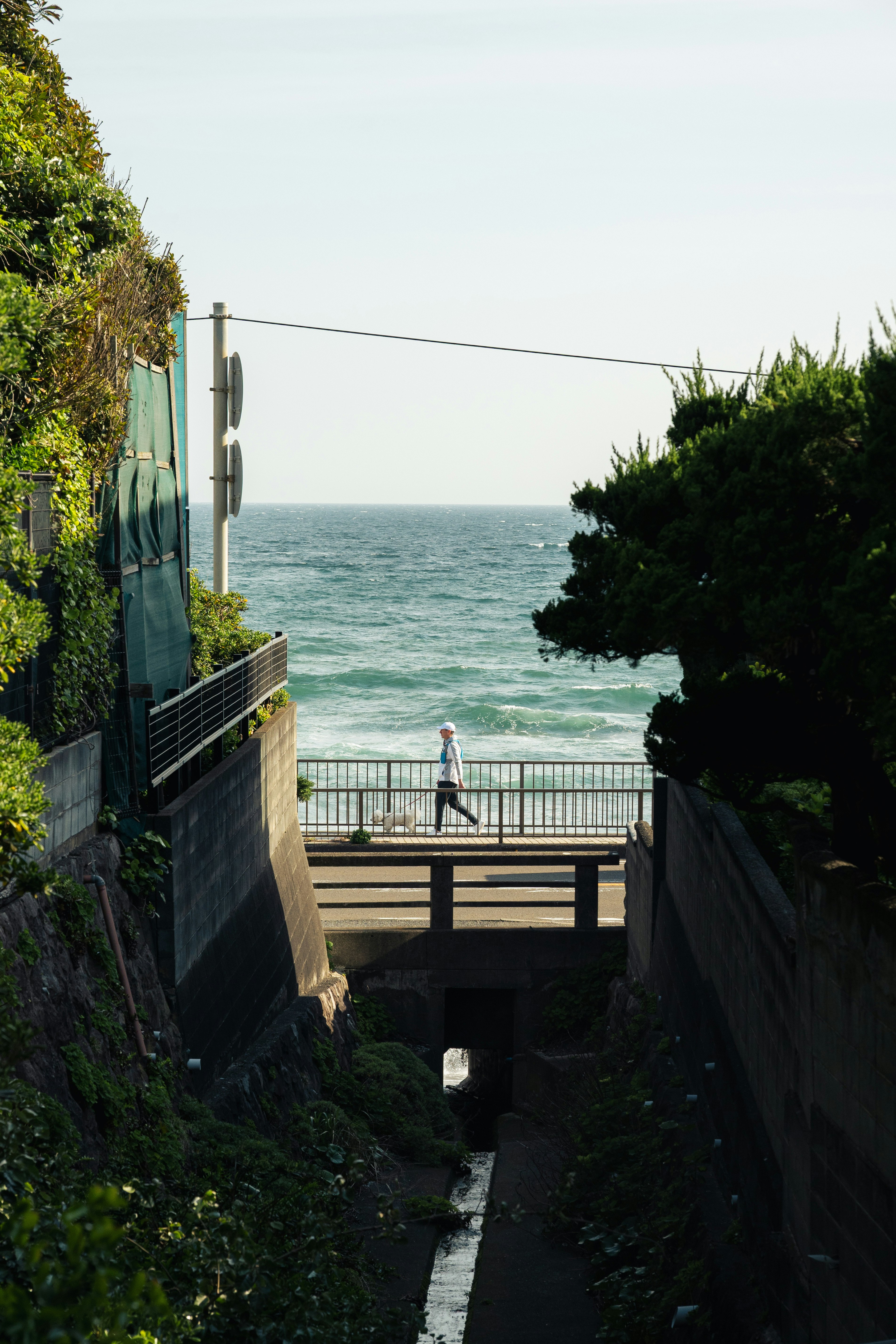 海邊步道的階梯與欄杆，行人走過