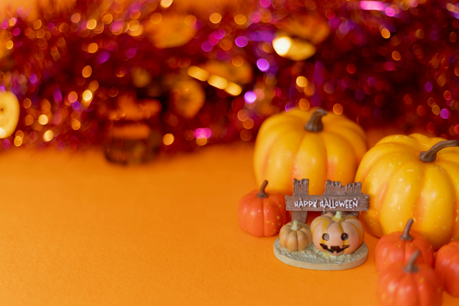 Piccole zucche gialle e decorazione di Halloween su uno sfondo arancione