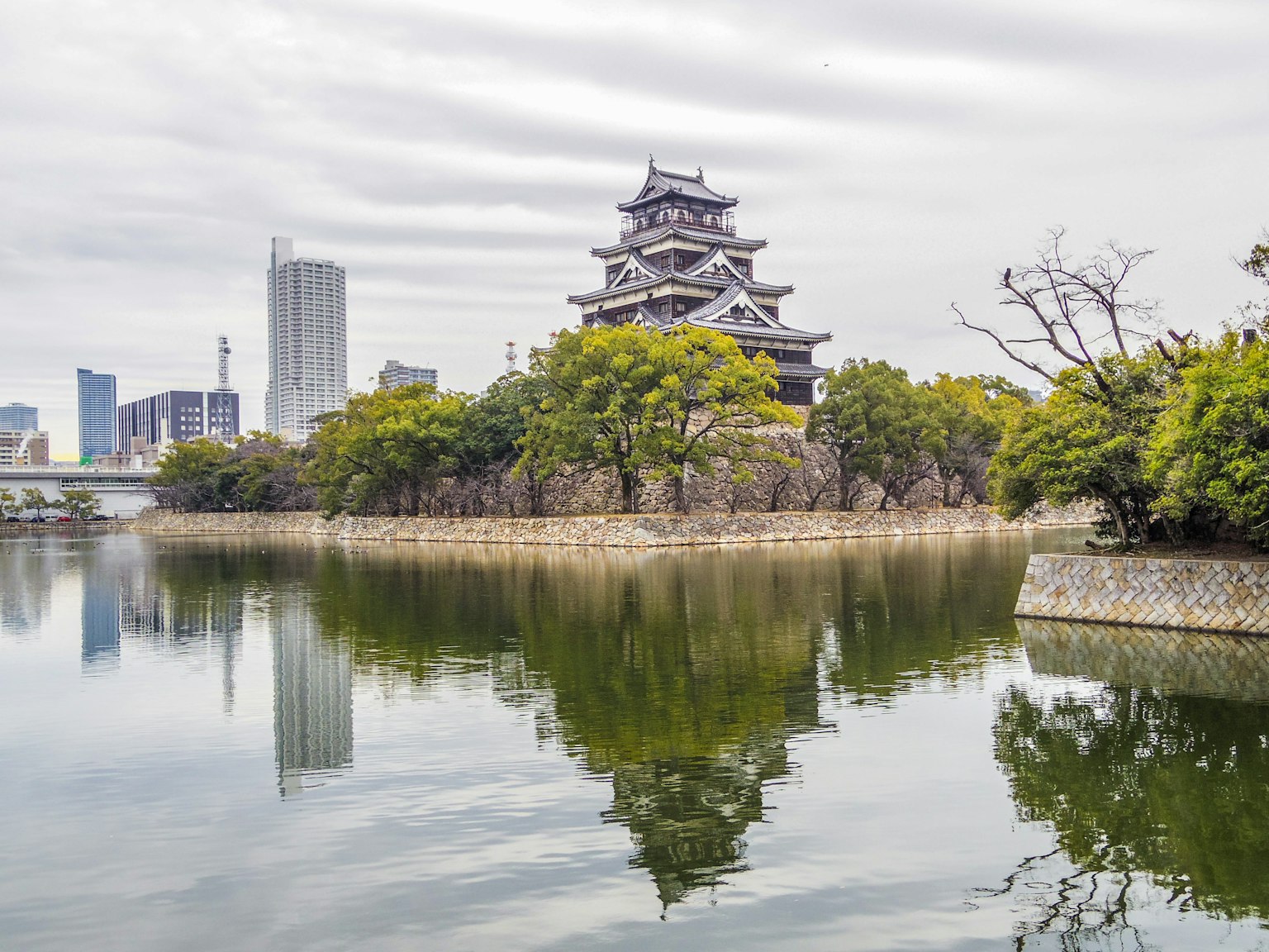 ปราสาทสวยงามที่ล้อมรอบด้วยทิวทัศน์เมืองและการสะท้อนในทะเลสาบที่สงบ