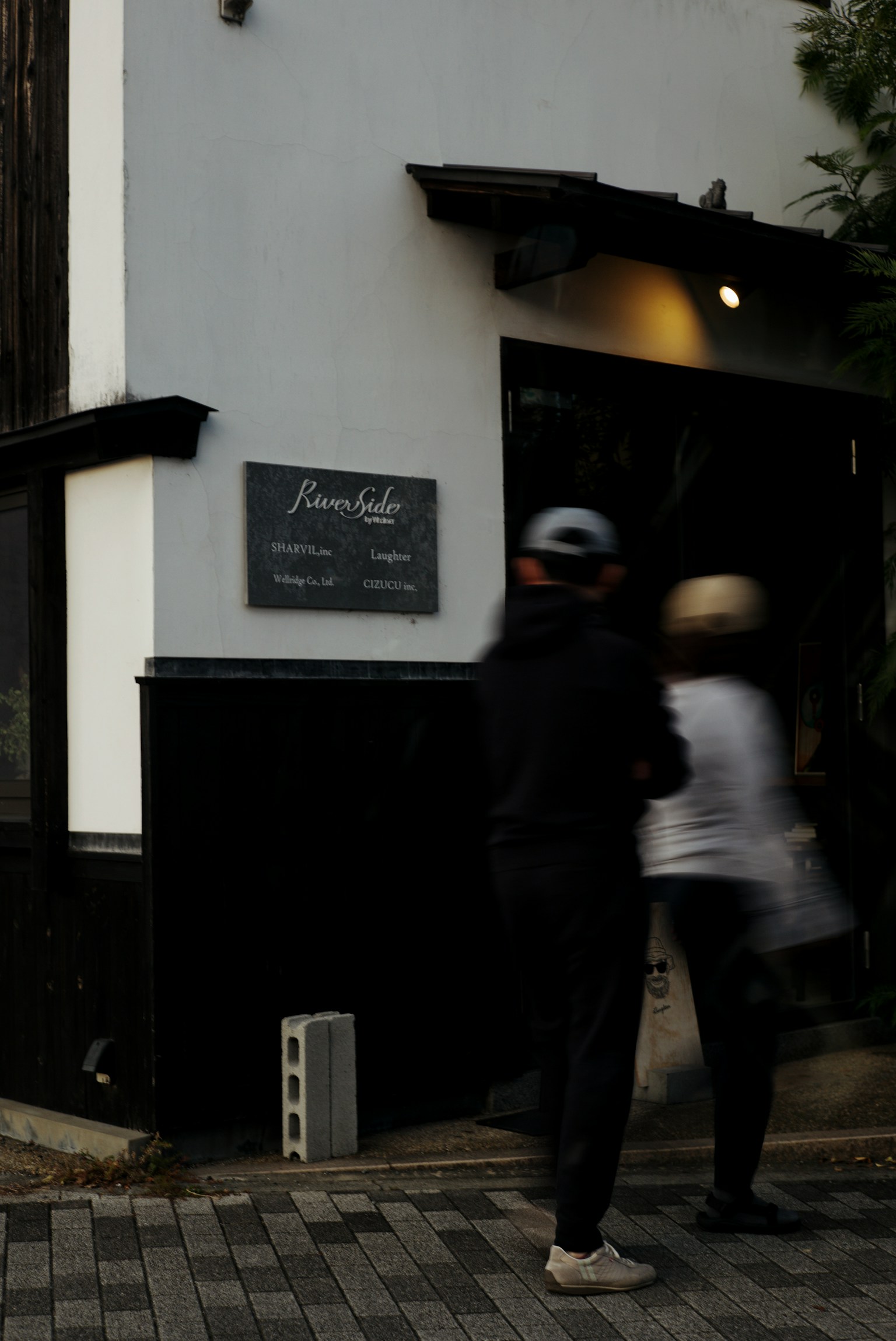 Exterior of a cafe with people passing by and a sign