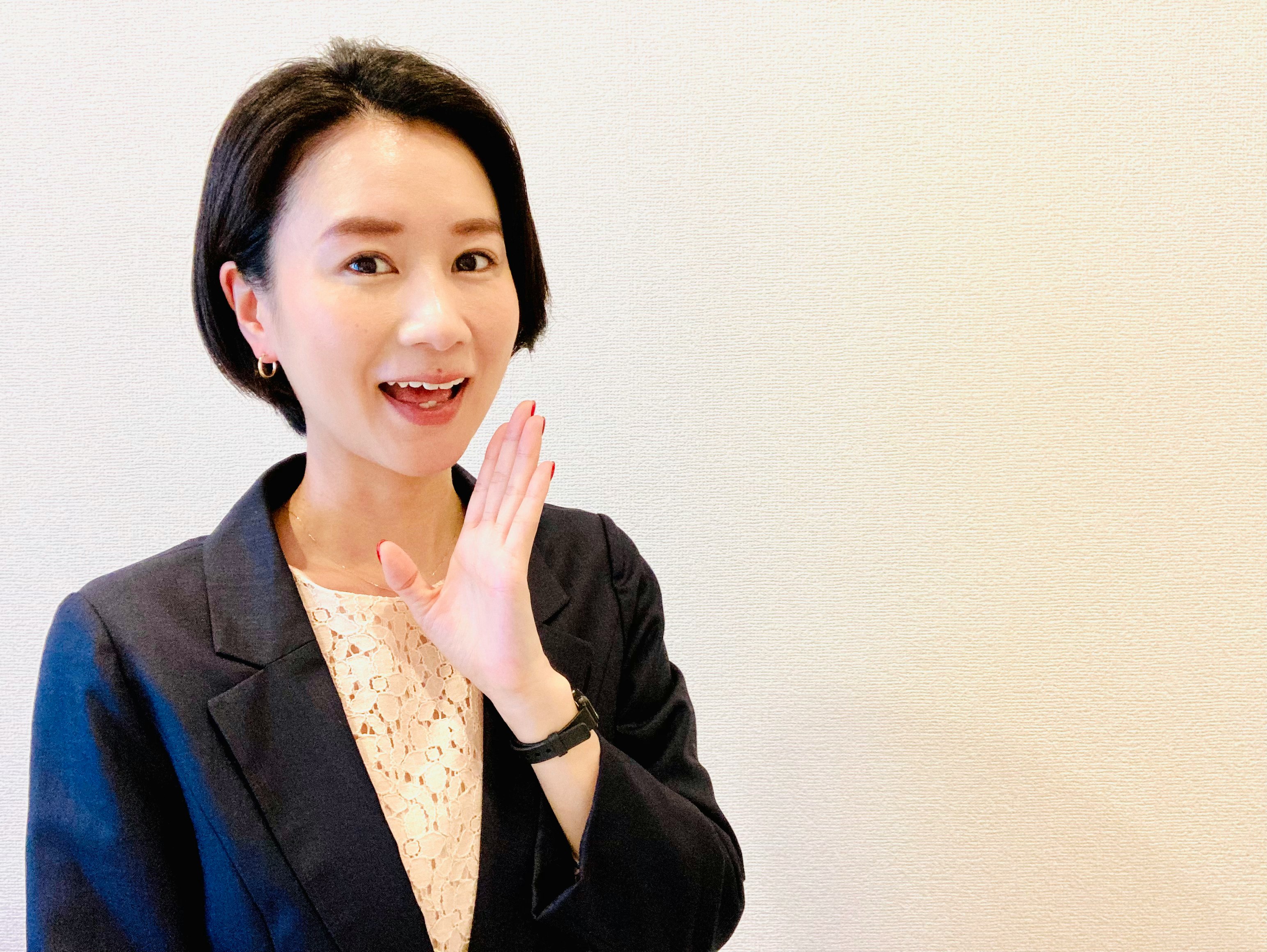 woman in a business suit waving
