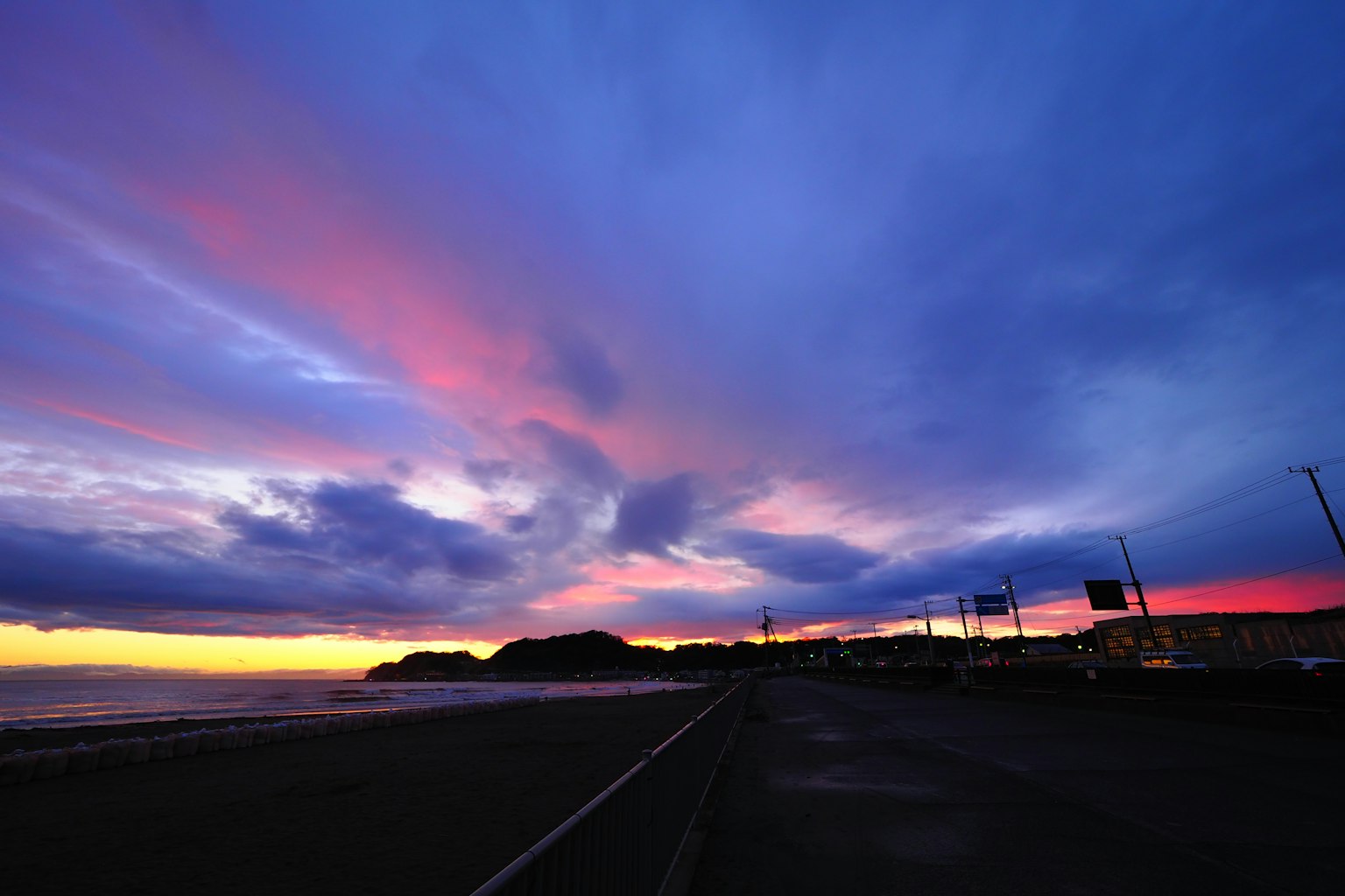 Paisaje costero con cielo de atardecer vibrante en púrpura y naranja