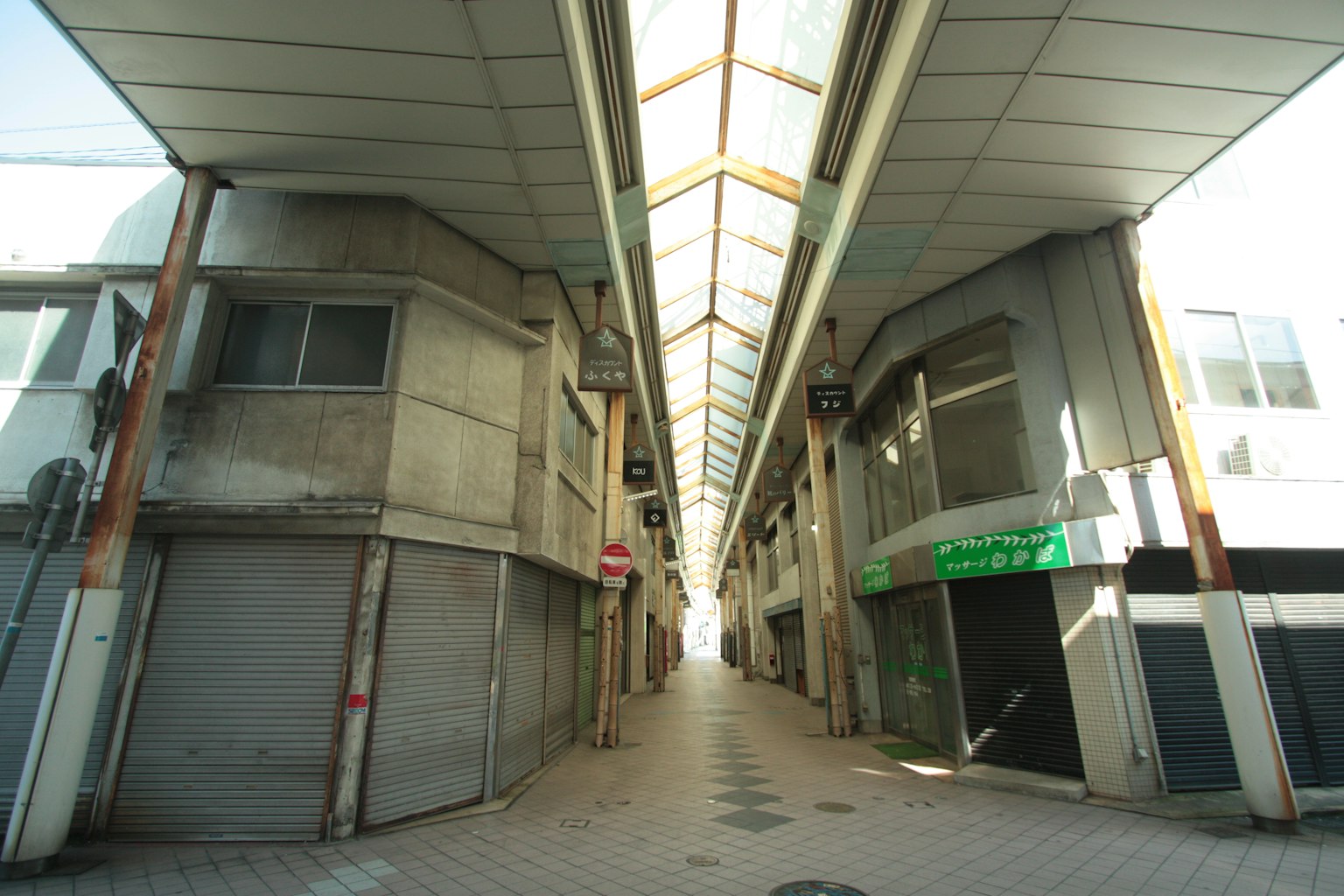 Photo d'une rue commerçante vide avec des magasins fermés de chaque côté