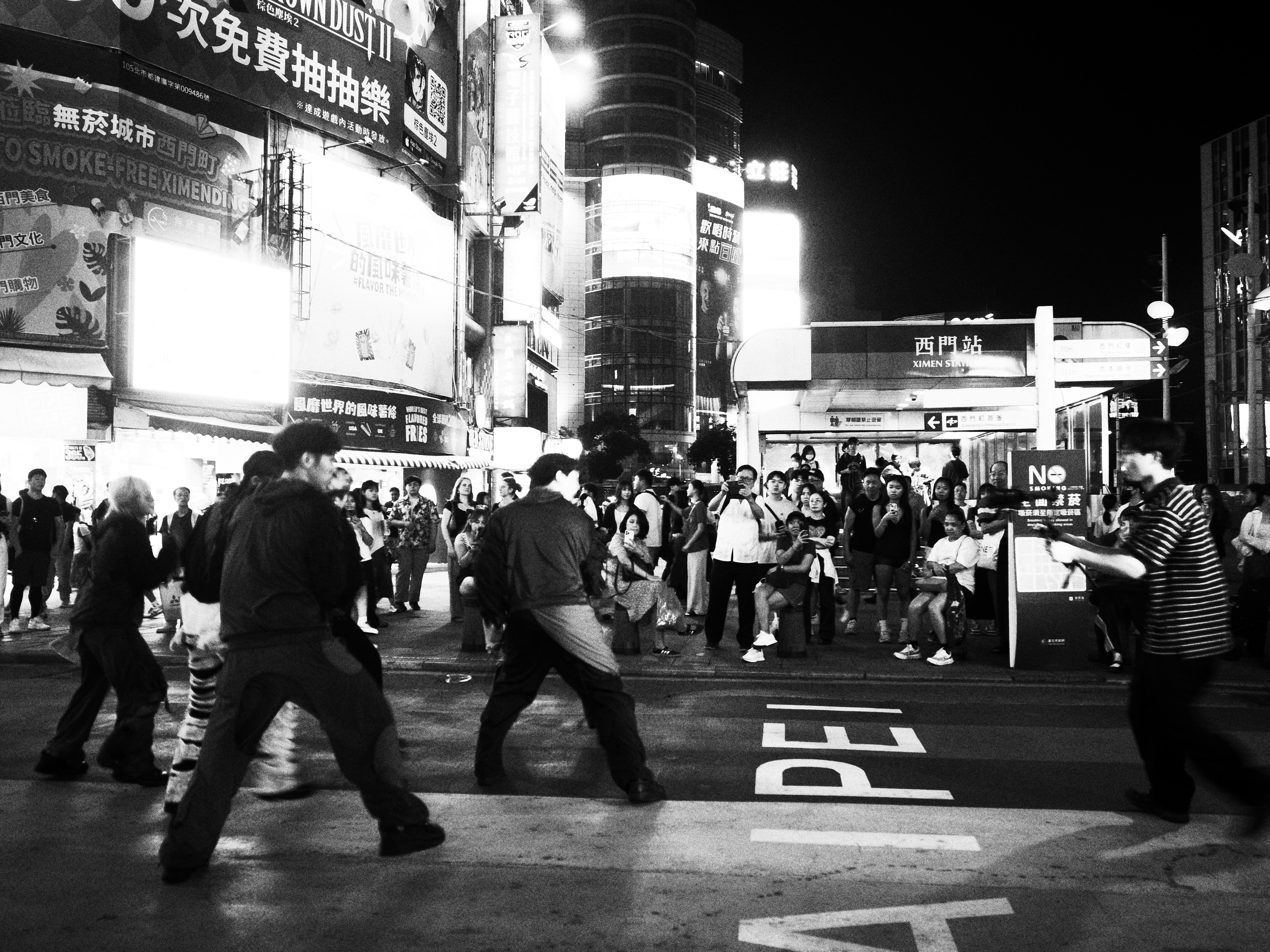 台北の夜の繁華街で人が行き交う交差点の街並み