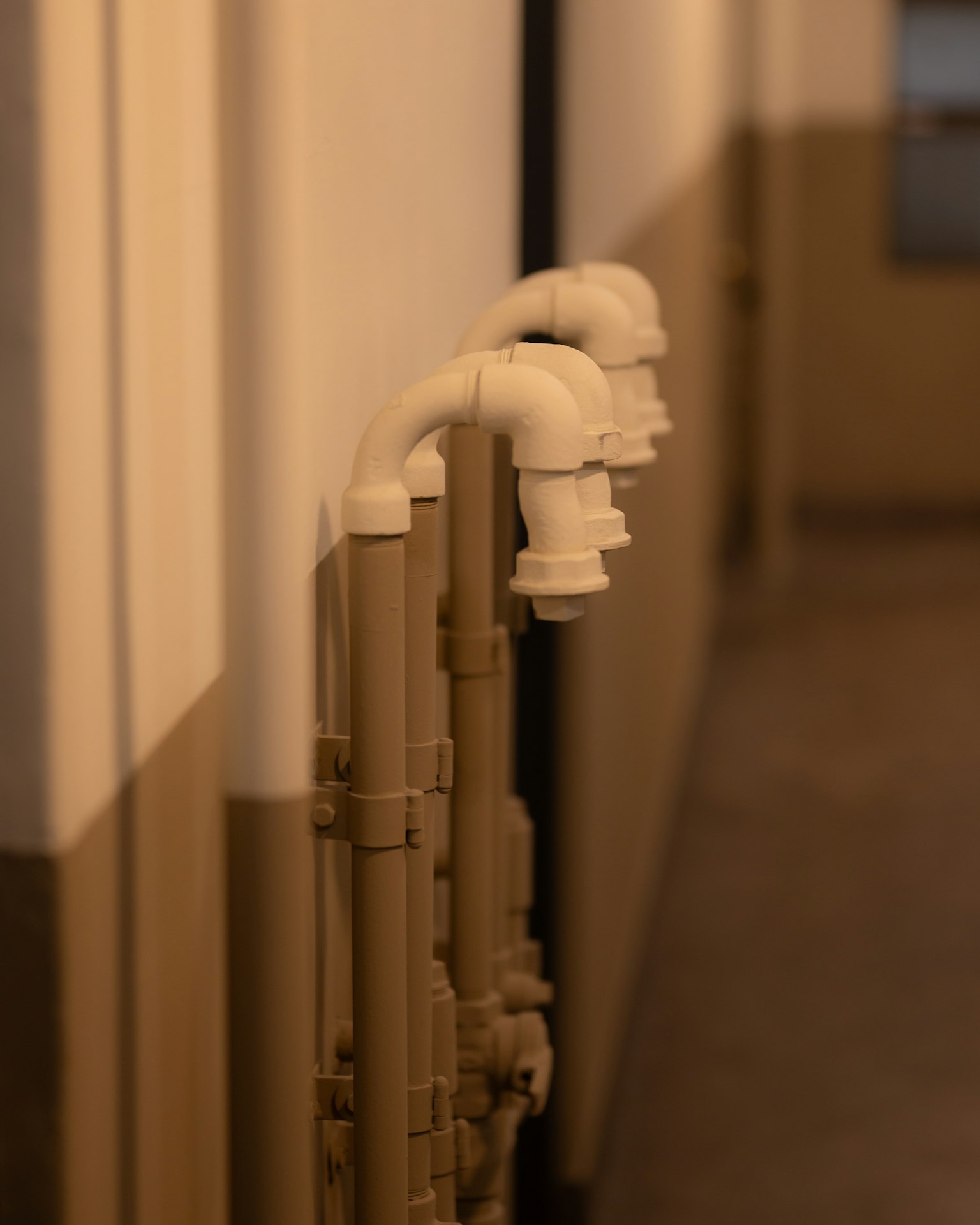 Tuyaux blancs alignés dans un couloir montrant un design unique