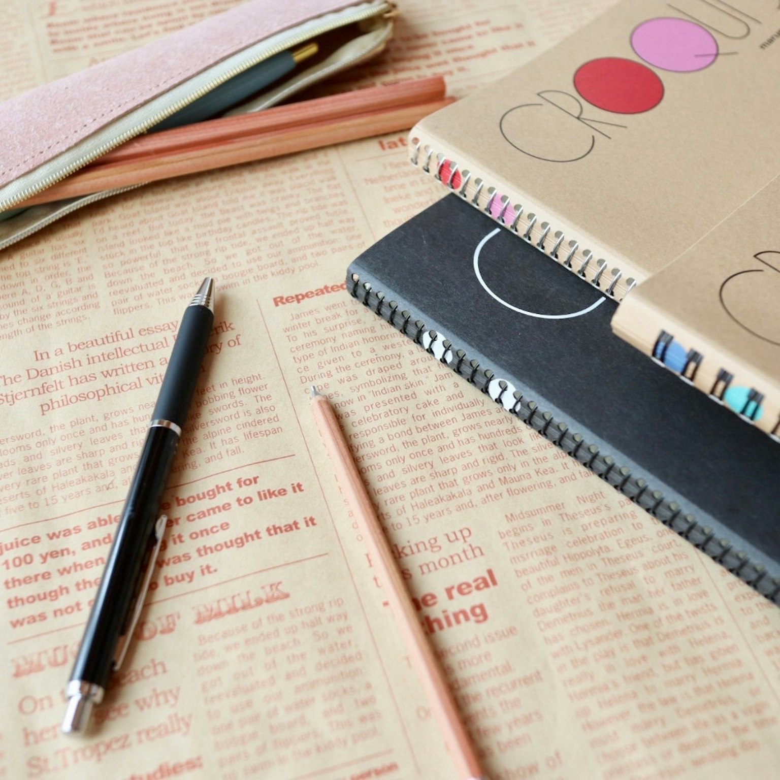 A flat lay of stationery and notebooks on a desk