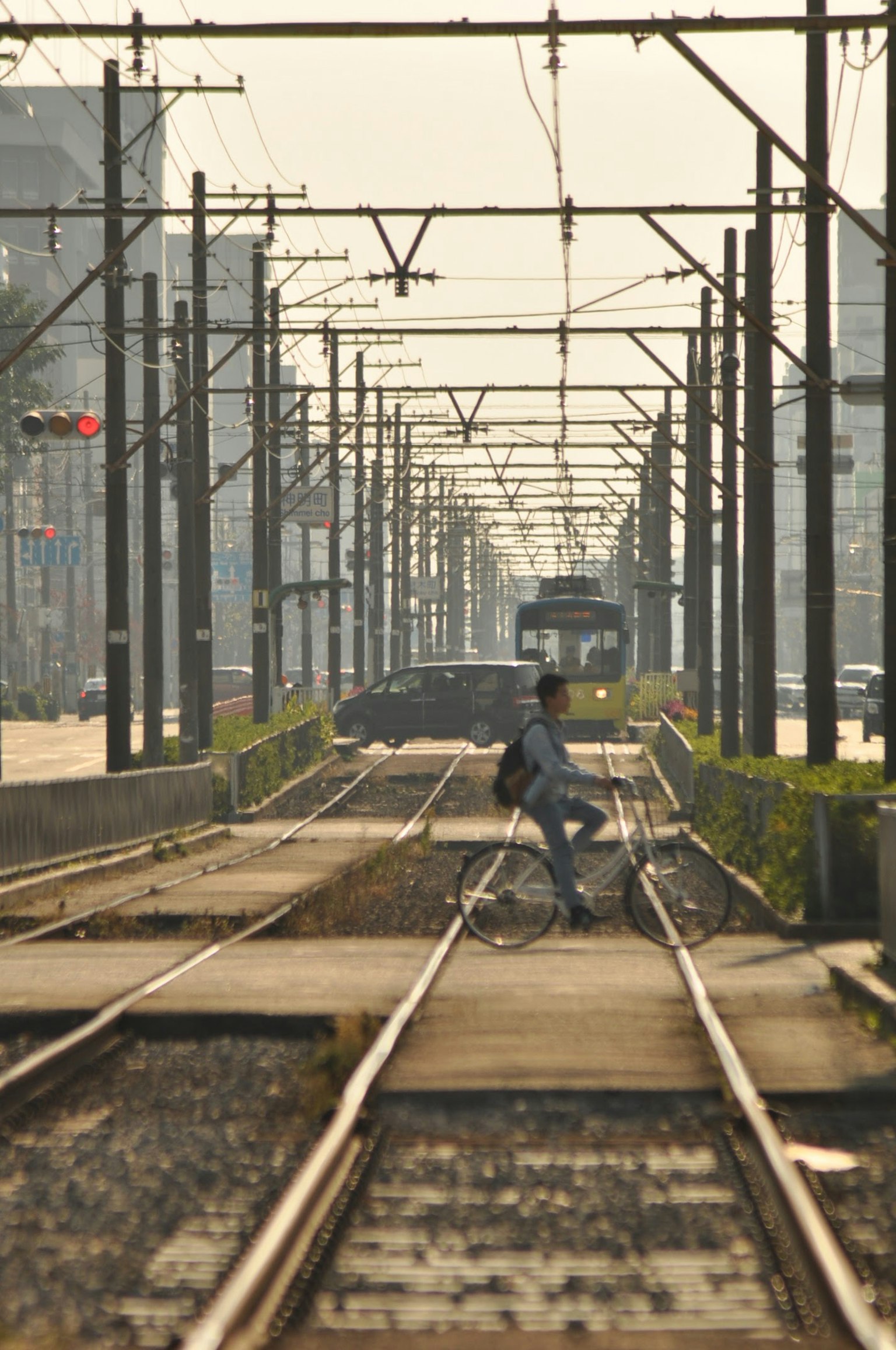 บุคคลบนจักรยานนั่งอยู่บนรางรถไฟพร้อมกับรถไฟที่อยู่ห่างออกไป