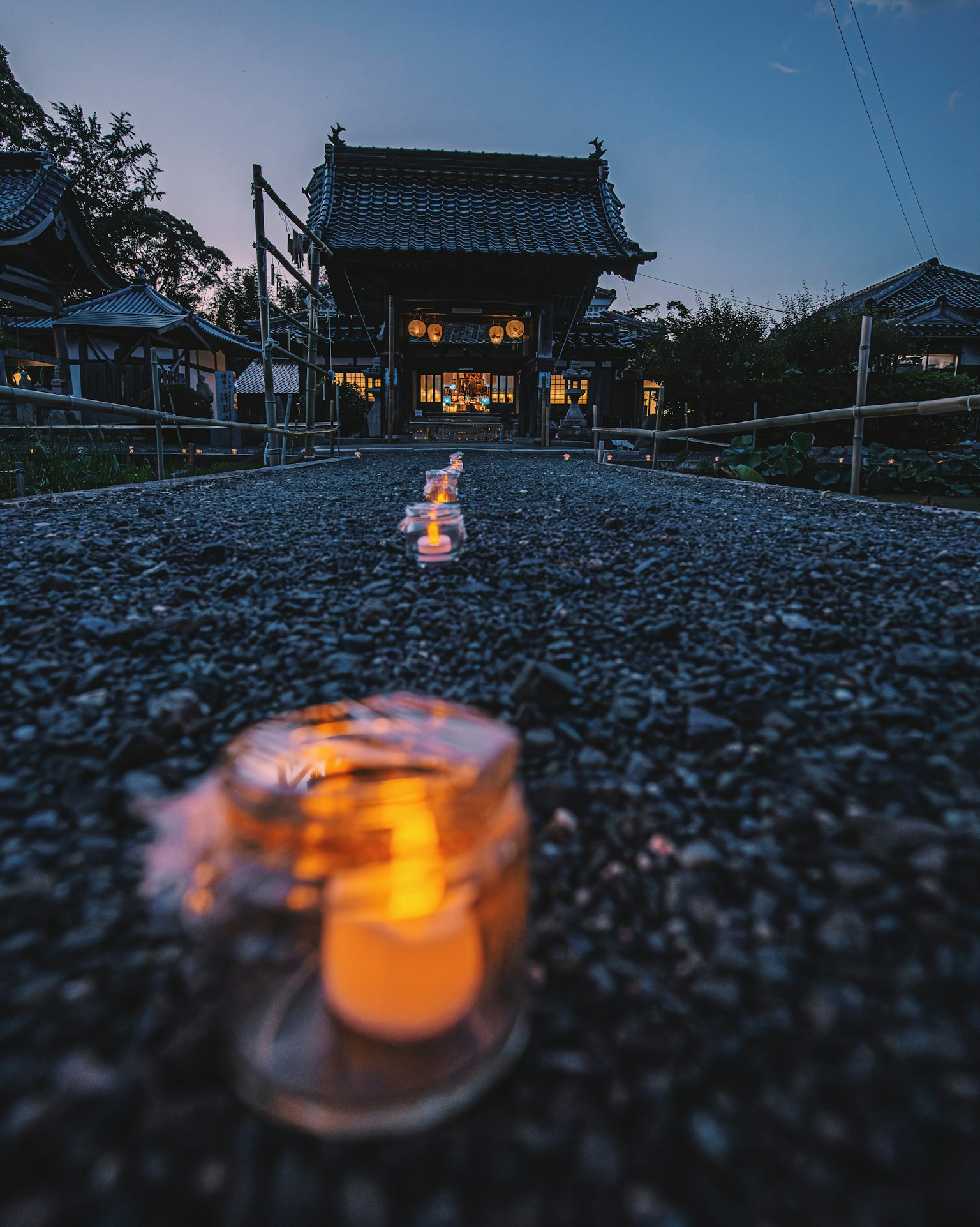 Ruhige Abendstimmung mit Kerzen entlang eines Steinwegs zu einem Tempel