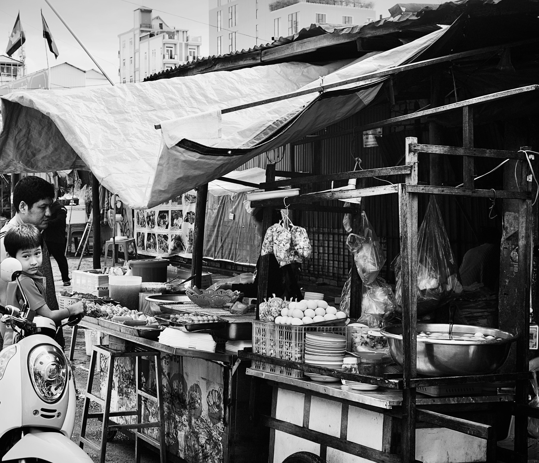 屋台の木製棚に並ぶ果物や食材の商店街