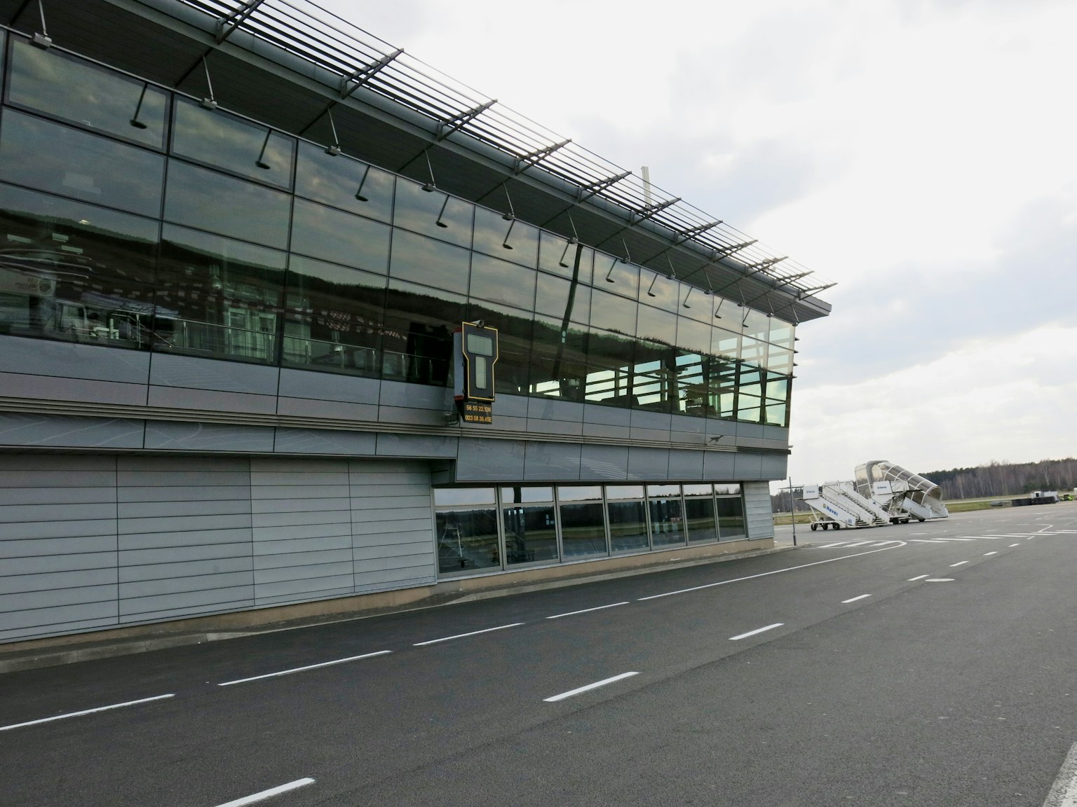 Extérieur d'un terminal d'aéroport moderne avec façade en verre et panneaux solaires sur le toit