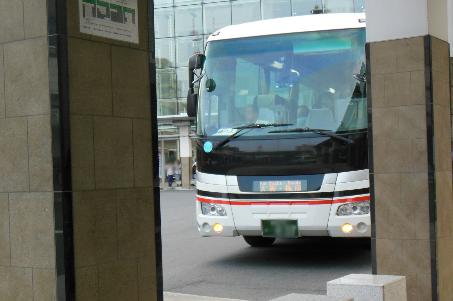 A bus passing through a building entrance