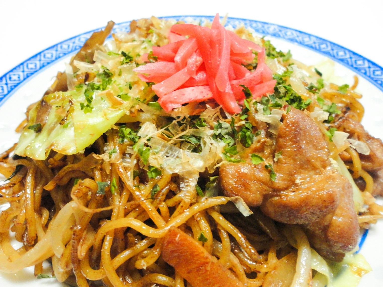 Piatto di yakisoba guarnito con verdure colorate e carne