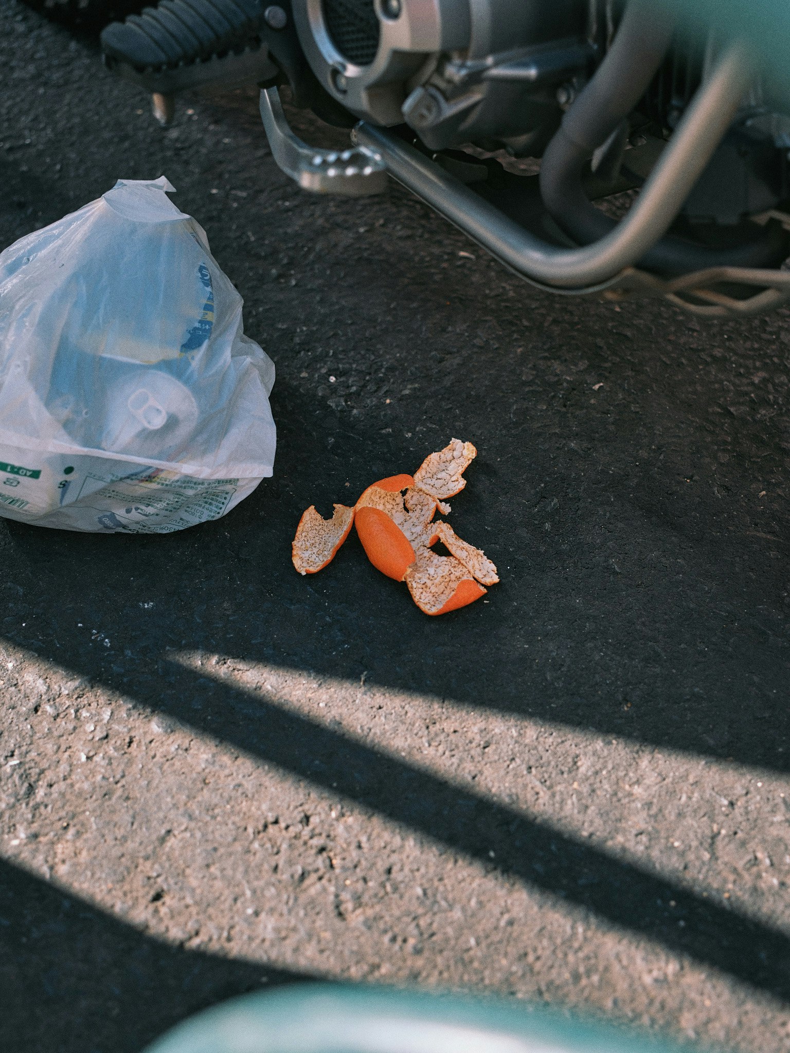fragmentos naranjas esparcidos en la calle junto a una bolsa