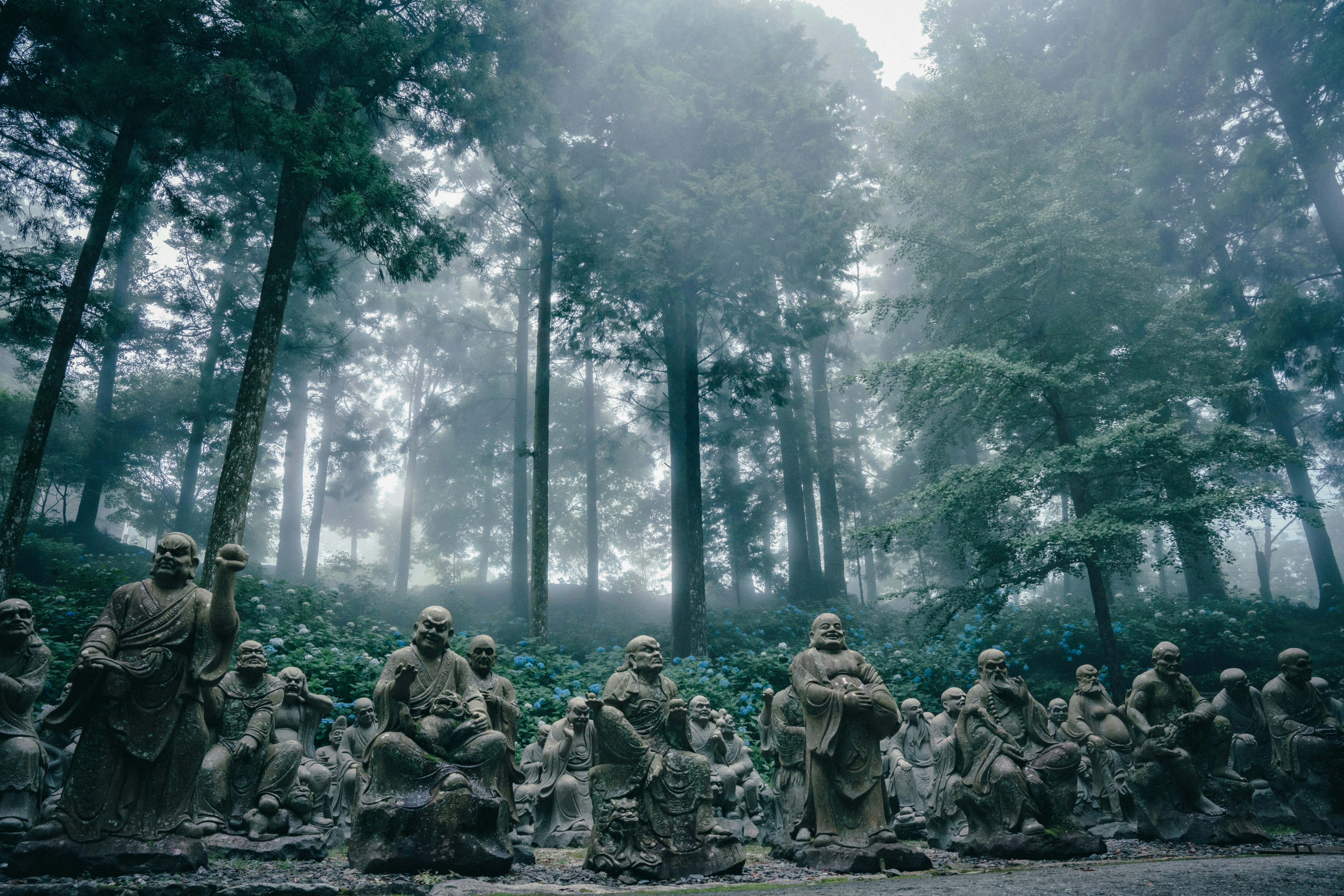 Estatuas de soldados de piedra alineadas en un bosque brumoso