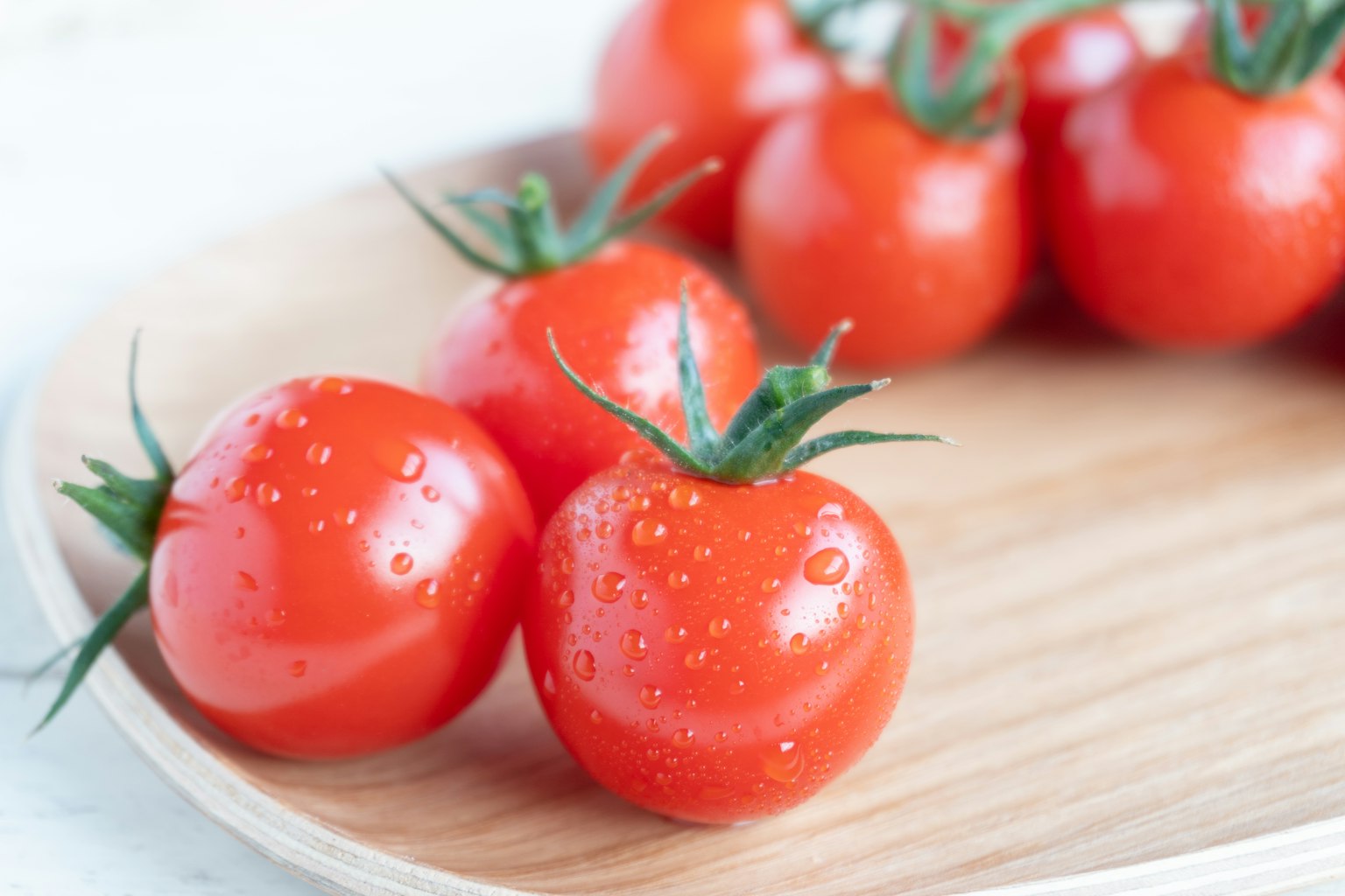 Tomates rojas frescas dispuestas en un plato de madera