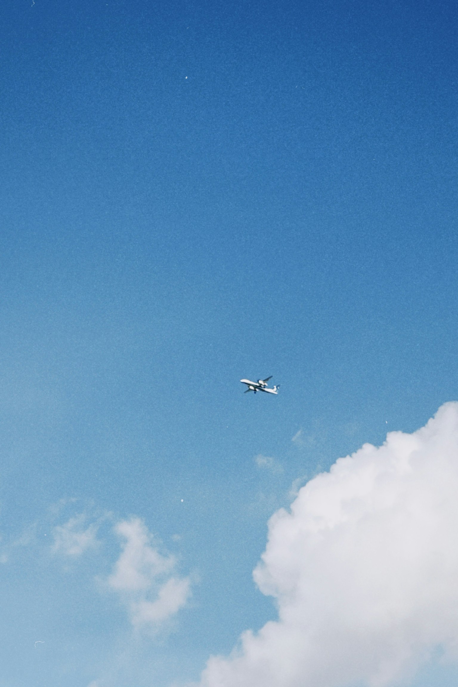青空に浮かぶ飛行機と白い雲