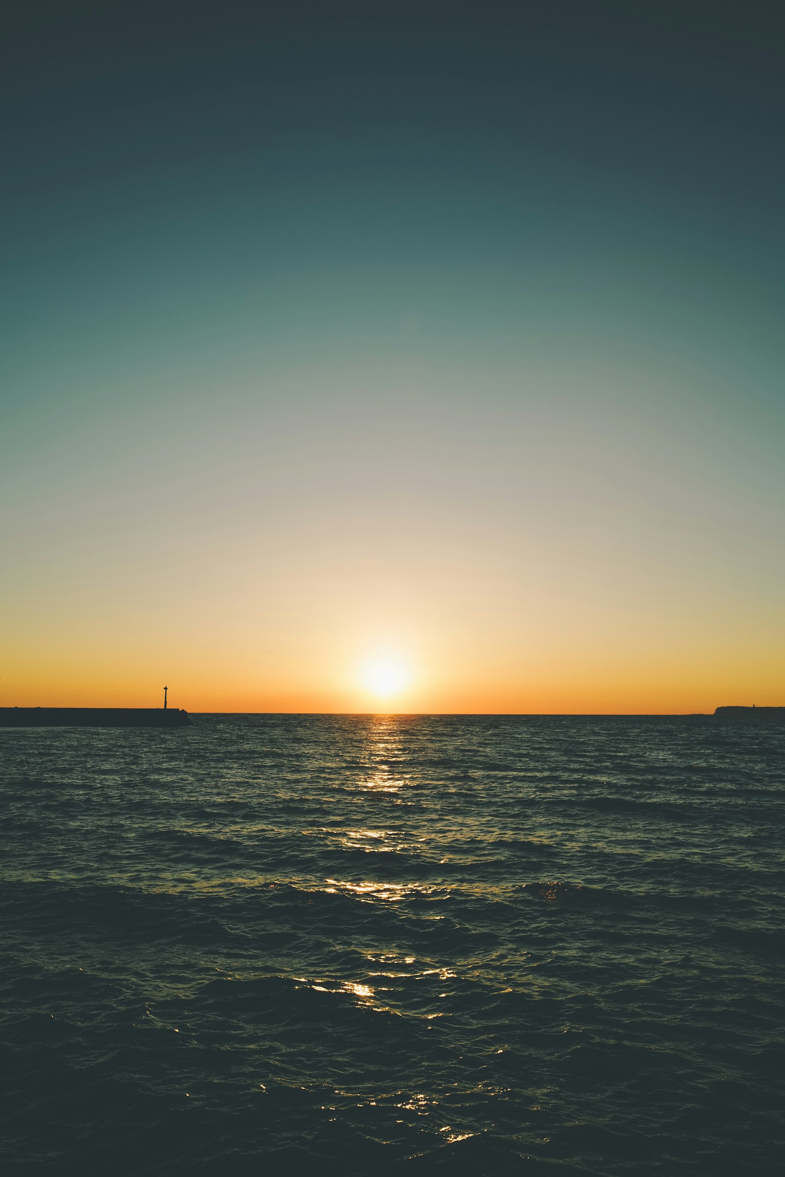 Beautiful sunset over the ocean horizon with calm waves
